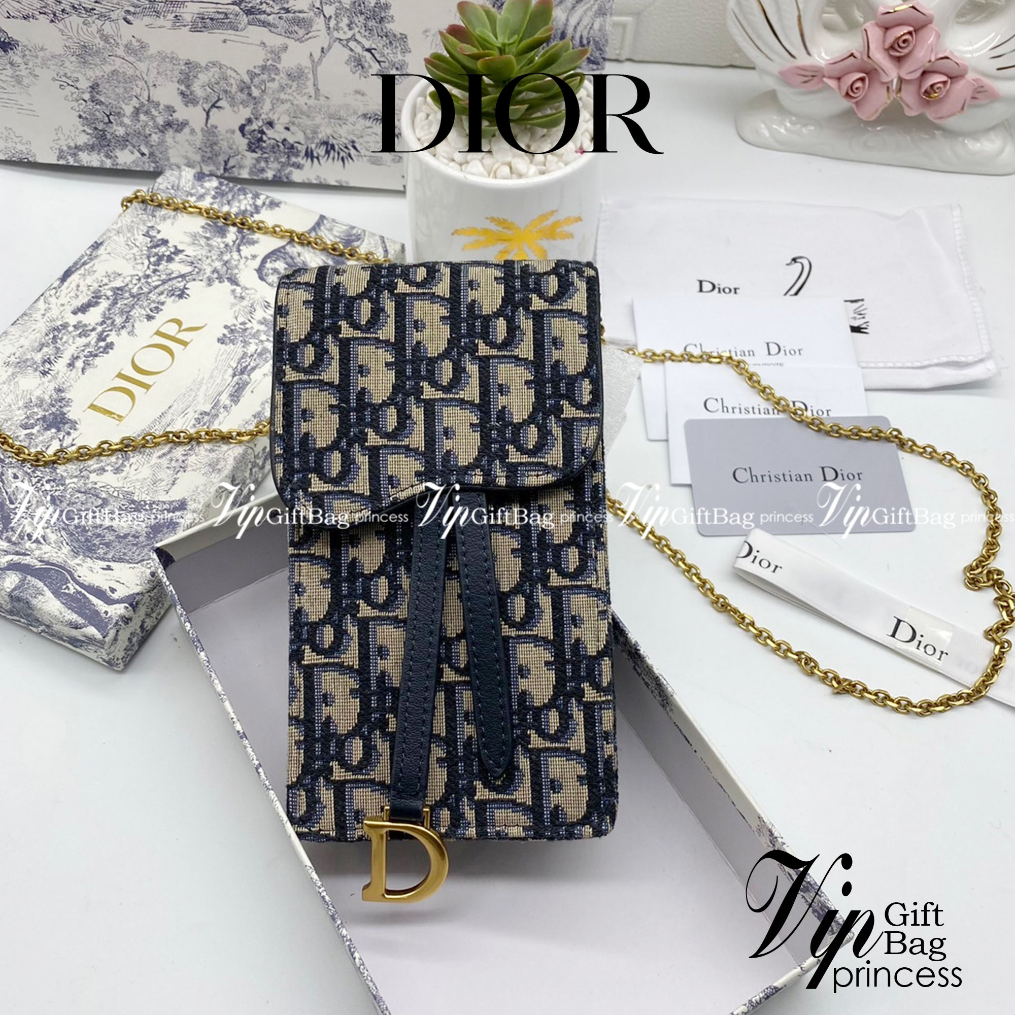 หนังแท้ DIOR PHONE BAG / DIOR PHONE HOLDER BAG กระเป๋าใส่โทรศัพท์เอกลักษณ์ของความหรู สายสะพายโซ่อะไหล่ทอง วัสดุหนังแท้และผ้า Jacquard อย่างดีสวยงามที่สุด ผสมผสานความสง่างามและคลาสสิกที่เข้ากับยุคสมัย ด้านหน้าโดดเด่นด้วยซิกเนเจอร์แบรนด์ เป็นอีกหนึ่งรุ่นที่