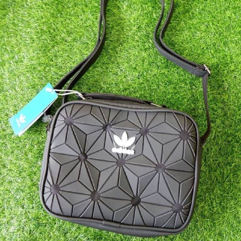 adidas mini airline bag *outlet* กระเป๋าสะพายข้างทรงสปอร์ต ด้านหน้าติดโลโก้แบรนด์ ดีไซน์ลาย 3D ด้านหลังเป็นหนังเรียบ มีช่องซิปสามารถใส่สิ่งของได้ รุ่นนี้เปิดปิดด้วยซิปคู่ ซิปปั๊มแบรนด์ทุกจุด ด้านในเป็นช่องกว้าง มีช่องซิป สายสะพายยาวสามารถปรับระดับได้ สาวก