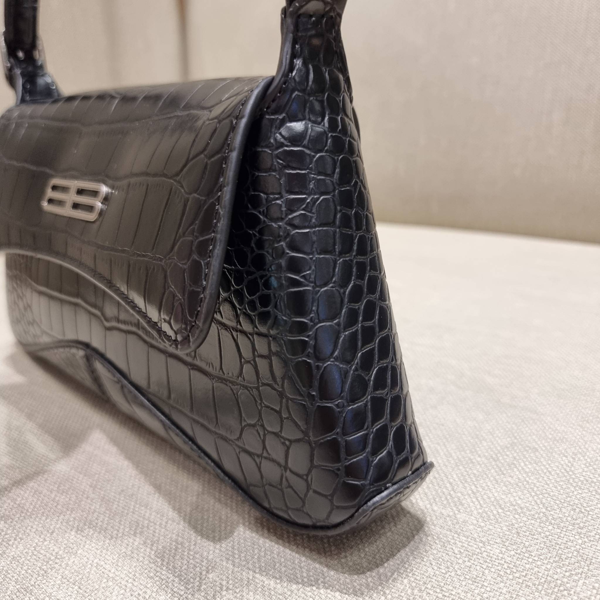 Balenciaga XX small flap bag กระเป๋าสะพายดีไซน์สวยเลิศ!! ไม่ซ้ำ เอกลักษณ์ที่โดดเด่นด้วยรูปทรง และขนาดที่กำลังเหมาะใช้งาน พร้อมดีไปหมด!! วัสดุหนังลายจระเข้ ขึ้นเงาคมชัด เปิด-ปิดด้วยกระดุมแม่เหล็ก ภายในกระเป๋าเป็นช่องโล่ง ใส่ของสำคัญจุกจิกพอได้ พกพาได้แบบไม