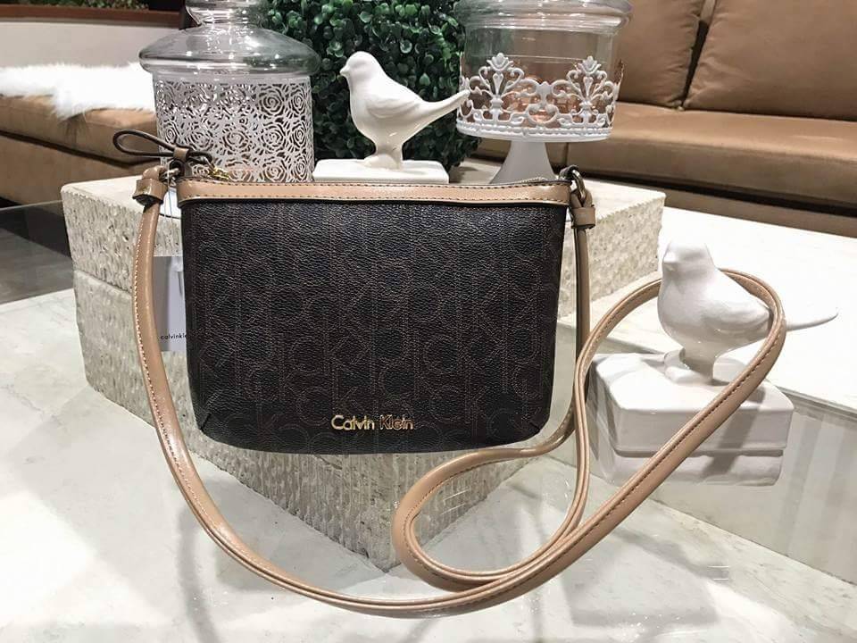 Calvin Klein Cross Body Bag กระเป๋าสะพายรุ่นใหม่ล่าสุดหนังสวย สกรีนลาย Signature แบรนด์รอบใบ ประดับโลโก้แบรนด์ สีทองด้านหน้า เปิดปิดด้วยซิป น้ำหนักเบา ภายใน โล่งกว้าง มีช่องใส่บัตร และช่องซิป ใส่ iphone+ ได้ มาพร้อมสายสะพายยาว ขนาดกำลังน่ารัก สะพายคล่องตั