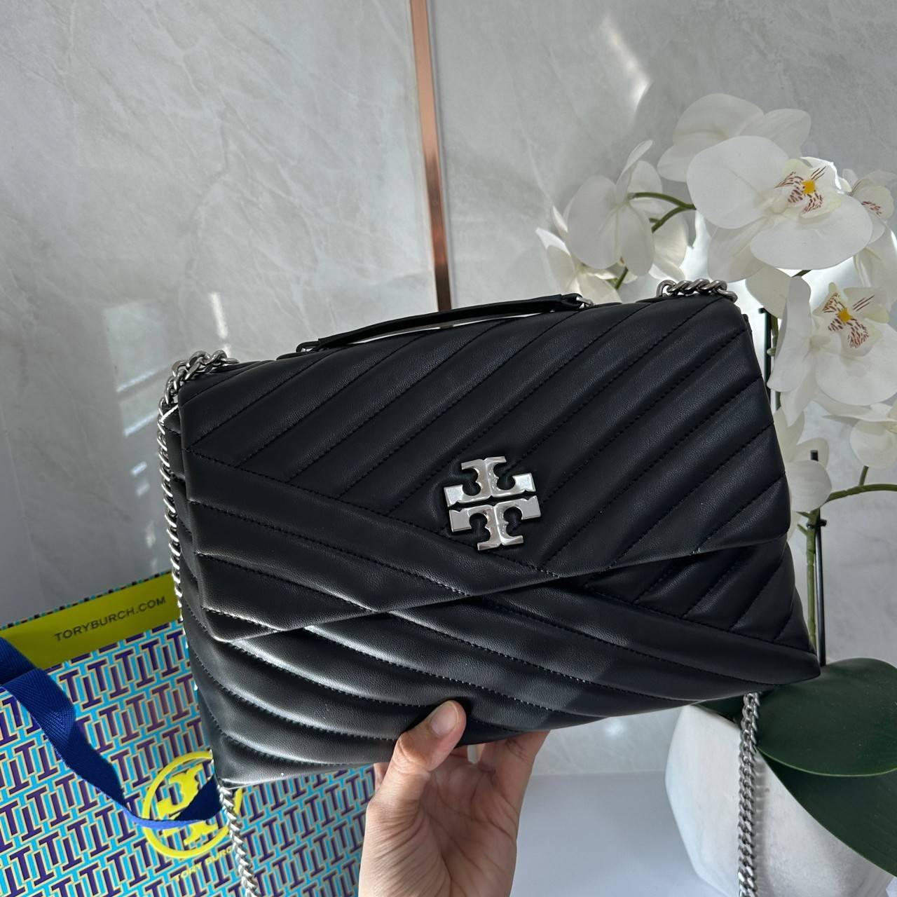 TORY BURCH KIRA CHEVRON CONVERTIBLE SHOULDER BAG กระเป๋าสะพายไซส์ใหญ่ หรูหราสุดคลาสสิก วัสดุหนังแกะทั้งใบ เปิด-ปิดด้วยกระดุมแม่เหล็ก ภายในเป็นช่องโล่ง ใส่ของสำคัญได้ครบ สายสะพายในตัวปรับได้ 2 แบบ สะพายไหล่โซ่คู่หรือจะ ครอสบอดี้ก็เริ่ดคะ