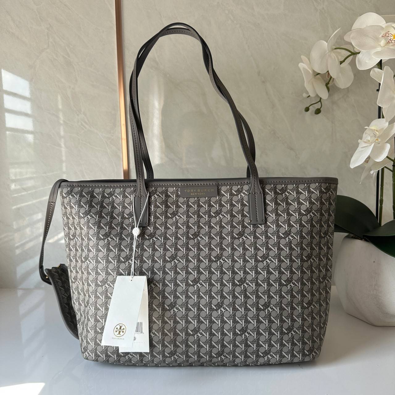 Tory Burch Ever Ready Zip Tote Small Coated Canvas / Tory Burch Geo Logo Tote กระเป๋าโท้ท พิมพ์ลายด้วยลวดลายสานตะกร้าอันเป็นเอกลักษณ์ของแบรนด์ ซึ่งได้แรงบันดาลใจจากความหลงใหลในงานจักสานของผู้ก่อตั้ง