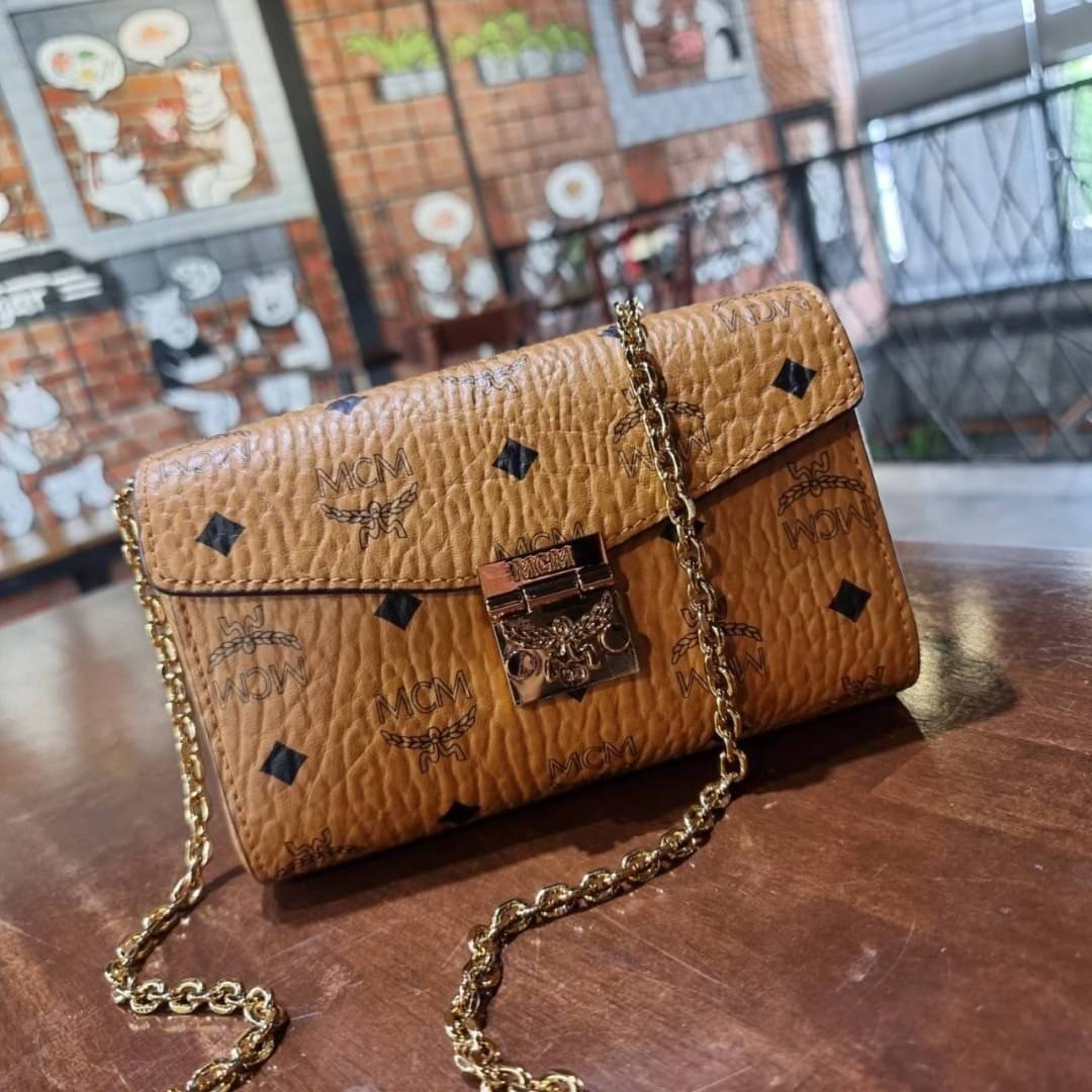 M.C.M SMALL MILLIE FLAP CROSSBODY IN VISETOS ไซส์ใหม่พกพาสะดวก!! กระเป๋าสะพายกึ่งคลัทช์ รอบนี้มาไซส์สวย สามารถใช้แทนกระเป๋าสตางค์ได้เลย ใส่โทรศัพท์มือถือได้ทุกรุ่น ใส่ของสำคัญสบายๆ มาพร้อมสายสะพายโซ่สีทองหรูหรา รูปทรงดีไซน์ร่วมสมัย ใช้งานง่ายด้วยตัวล็อค ว