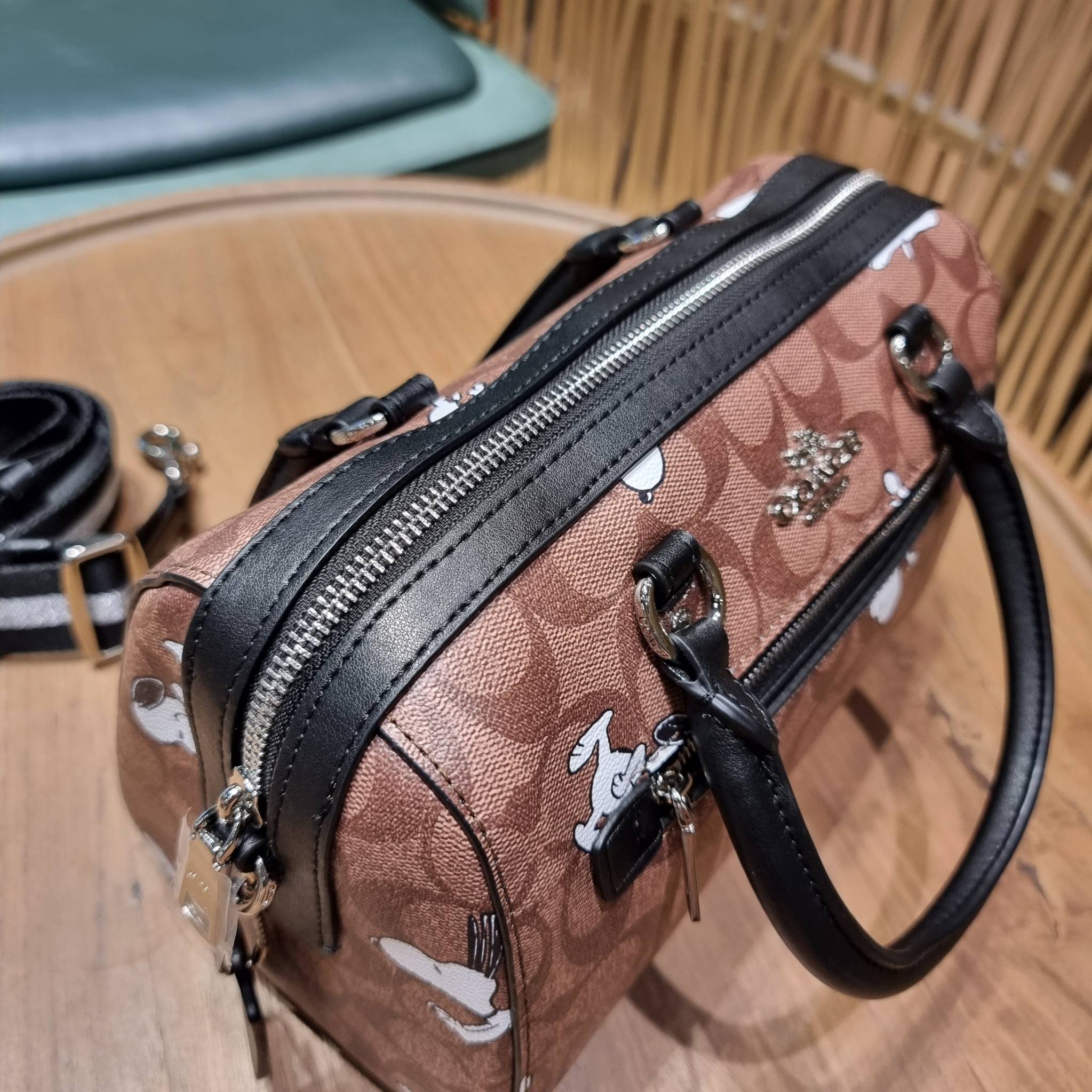 COACH C4118 COACH x PEANUTS ROWAN SATCHEL IN SIGNATURE CANVAS WITH SNOPPY PRINT สนูปพีที่สุดของคอลเลคชั่นแห่งความน่ารัก มาในดีไซน์ของกระเป๋าทรงหมอนยอดฮิต คลาสสิคใช้งานได้ไม่มีเบื่อ รอบนี้มาให้พร้อมสายสะพาย crossbody แบบสปอร์ต ทำให้ใช้งานได้อย่างกระฉับกระเ
