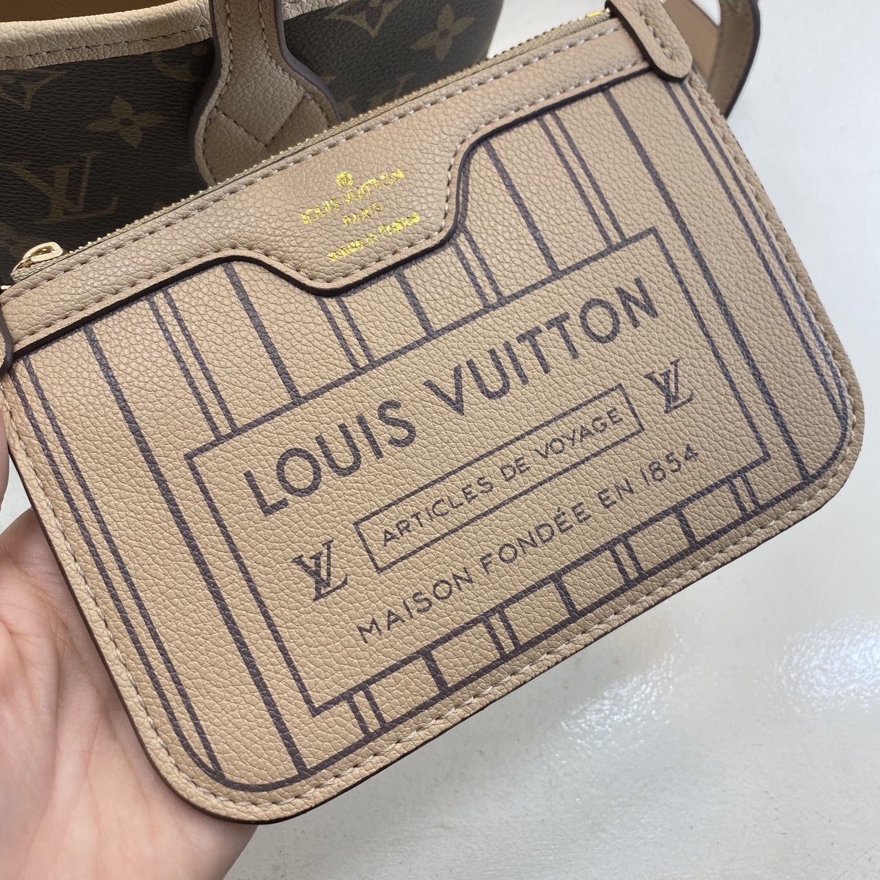 LV Neverfull Bandoulière Inside Out BB Bag กระเป๋าทรงโท้ทไซส์เล็ก พร้อมใบลูกพิมพ์ลายแบรนด์สุดไอคอนิก ดีไซน์ใช้งานได้ทั้งสองด้าน ด้านหนึ่งรังสรรค์จาก Monogram แคนวาสเป็นเอกลักษณ์