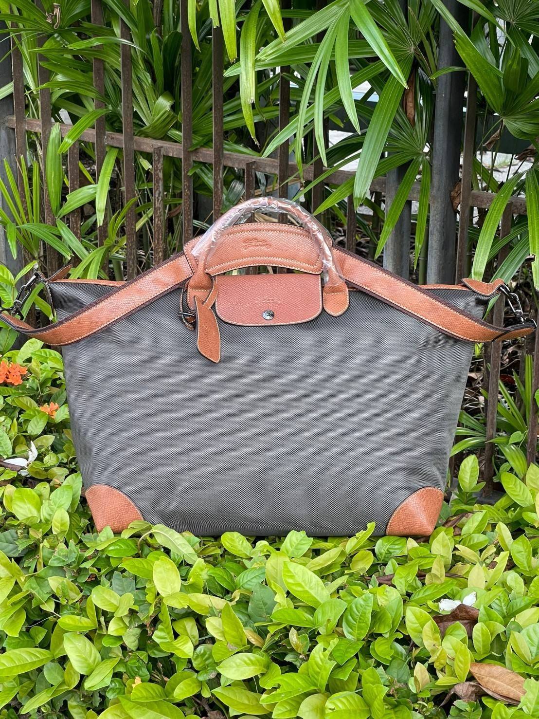 LONGCHAMP BOXFORD TRAVEL BAG L กระเป๋าเดินทางขนาดใหญ่ มาพร้อมสายสะพายที่สามารถถอดได้ ให้คุณเลือกสะพายไหล่หรือถือได้ มีซิปรูดเปิดปิดกระเป๋าที่ให้คุณมั่นใจได้ว่าคุณจัดเก็บไอเท็มของคุณได้อย่างมิดชิด บ็อคฟอร์ด (BOXFORD) สะท้อนความเป็นเอกลักษณ์ของแบรนด์ที่เปี่