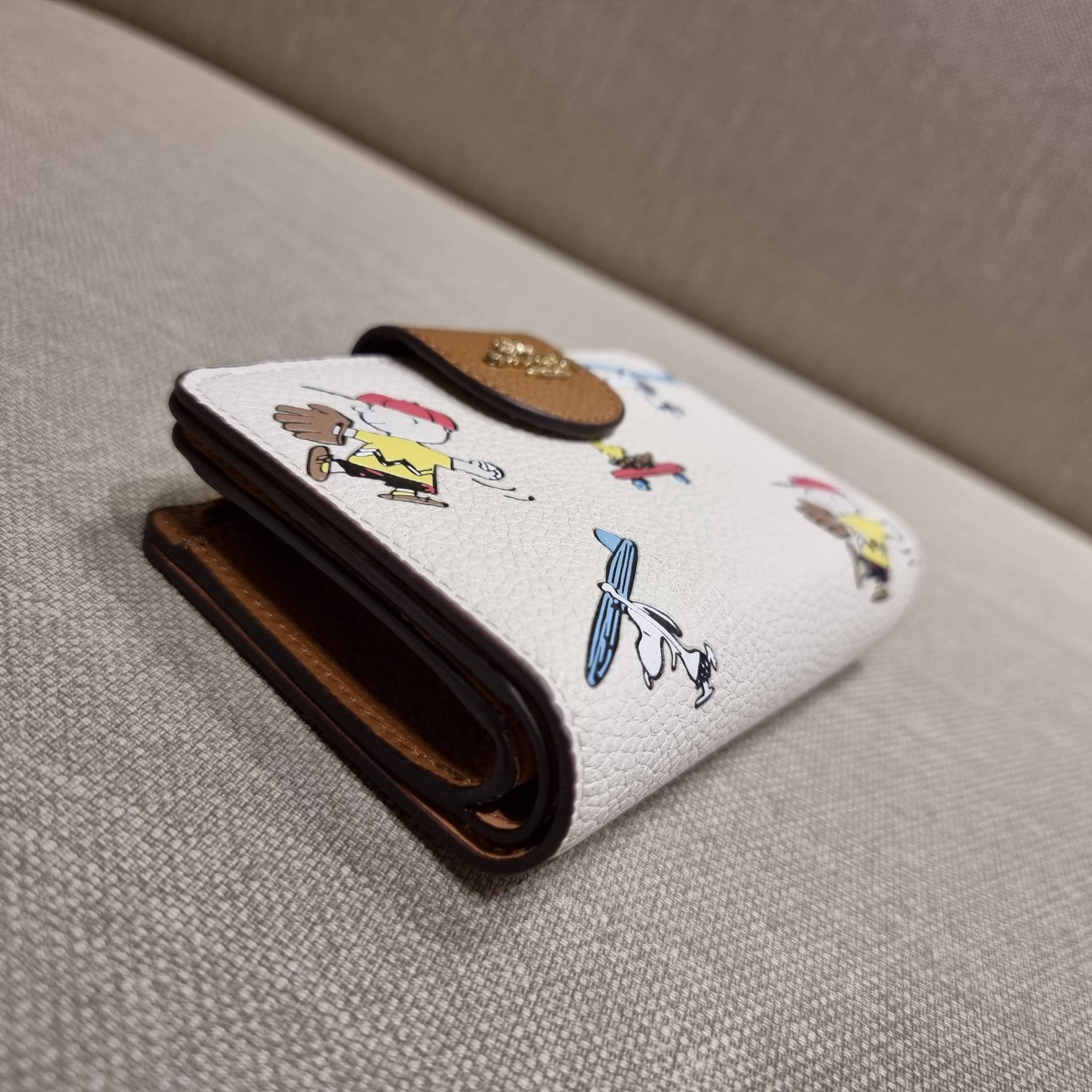 COACH C4899 MEDIUM CORNER ZIP WALLET WITH SNOPPY PRINT น้องใหม่คอลเลคชั่นสุดชิค ดีไซน์ลายพริ้นท์ผองเพื่อนสนูปพี น่ารักน่าใช้ เพิ่มลูกเล่นให้กระเป๋าสตางค์ของคุณไปอีก กับกระเป๋าสตางค์ใบกลาง ขนาดกำลังเหมาะมือ วัสดุหนัง pepble ทนทาน มีช่องใส่บัตรและธนบัตรครบ 