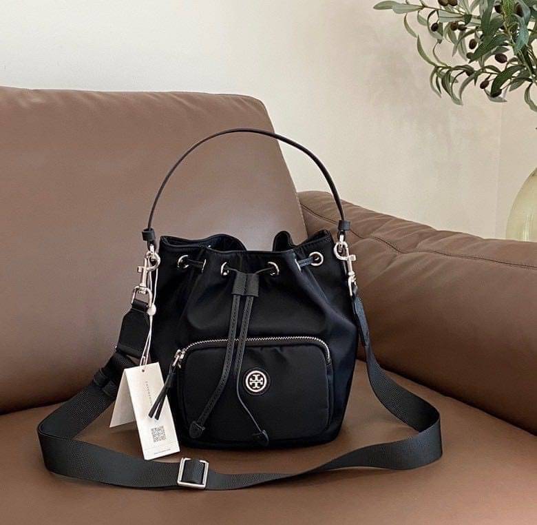 Tory Burch Virginia Nylon Bucket Bag / Tory Burch logo-plaque bucket bag กระเป๋าสะพายทรงบัคเก็ต เปิด-ปิดหนังรูดปากกระเป๋า มีหูหิ้วในตัว คล้องแขนเก๋ๆ ภายในเป็นช่องโล่ง มีช่องย่อย ใส่ของสำคัญจุกจิกได้ มีสายครอส จะสะพายไปไหนก็ได้ทุกโอกาส สวยเลิศทุกสี พร้อมส่
