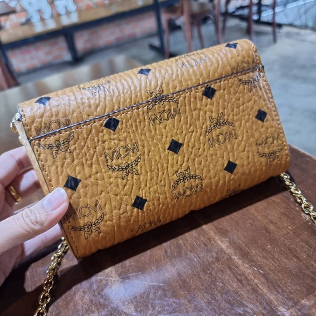 M.C.M SMALL MILLIE FLAP CROSSBODY IN VISETOS ไซส์ใหม่พกพาสะดวก!! กระเป๋าสะพายกึ่งคลัทช์ รอบนี้มาไซส์สวย สามารถใช้แทนกระเป๋าสตางค์ได้เลย ใส่โทรศัพท์มือถือได้ทุกรุ่น ใส่ของสำคัญสบายๆ มาพร้อมสายสะพายโซ่สีทองหรูหรา รูปทรงดีไซน์ร่วมสมัย ใช้งานง่ายด้วยตัวล็อค ว