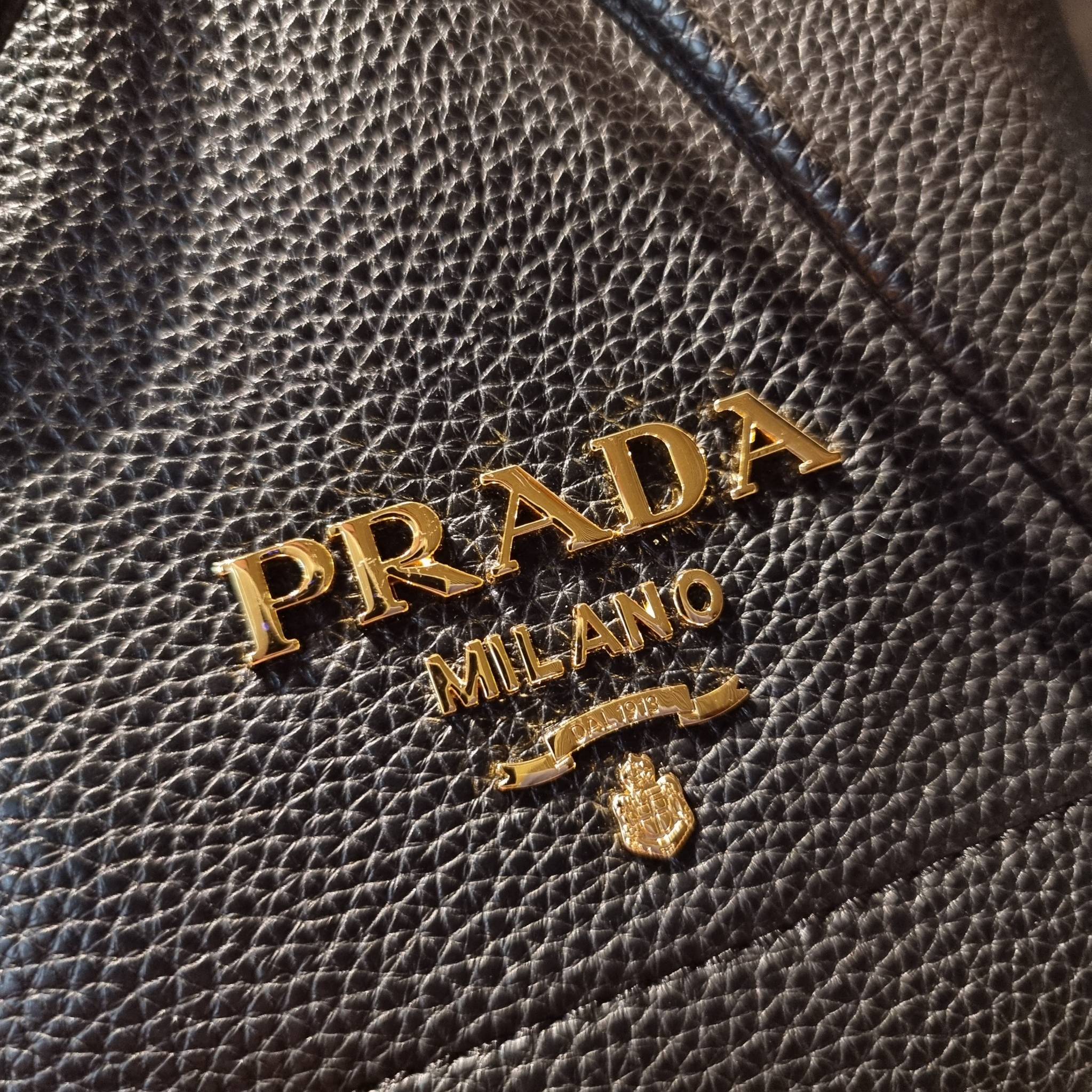Prada leather bucket bag กระเป๋าสะพายทรงขนมจีบ ดีไซน์เรียบ แต่หรู น่าใช้มากๆ หนังสวยมาก วัสดุหนัง pepble สัมผัสนิ่มมือ ตกแต่งโลโก้สีทองตัดหนังดำ คือเลิศ!! ปากกระเป๋ารูดเปิดปิดได้ สะดวกใช้งาน ภายในโล่งกว้าง จุของได้เยอะ ไม่ธรรมดาเลย พิเศษ!! นอกจากสายคล้องใ