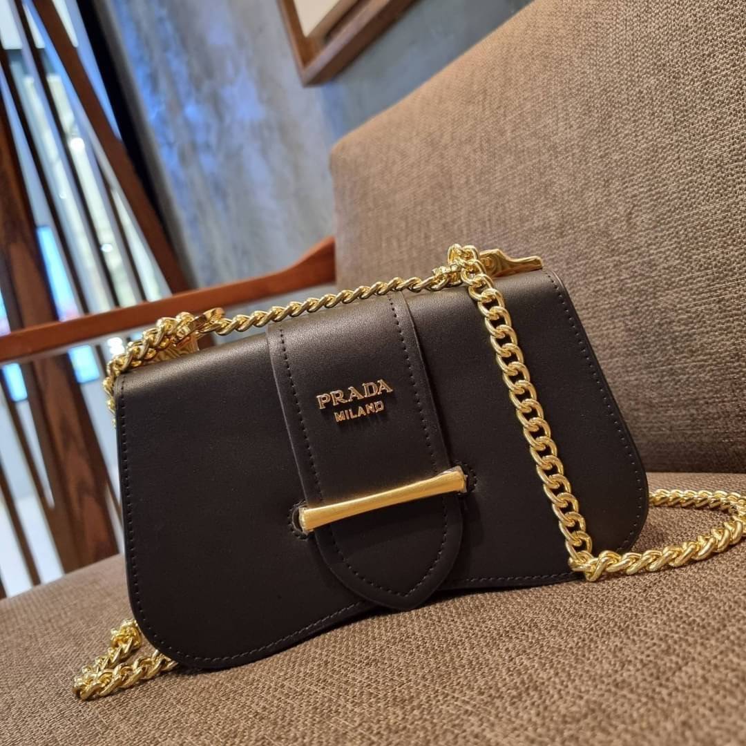 PRADA FRAGRANCE SHOULDER BAG WITH GWP ไอเท็มสุดโปรดที่ควรค่าแก่การครอบครองและเก็บสะสม กระเป๋าสะพายไหล่ สวยคม สีดำคลาสสิคตัดกับอะไหล่ทองเป็นอย่างดี วัสดุหนังแท้เต็มใบ เปิดปิดด้วยแถบหนังสอดในช่อง ใช้งานสะดวก พกพาง่าย ขนาดกำลังสวย สายสะพายในตัว สะพายได้หลากห