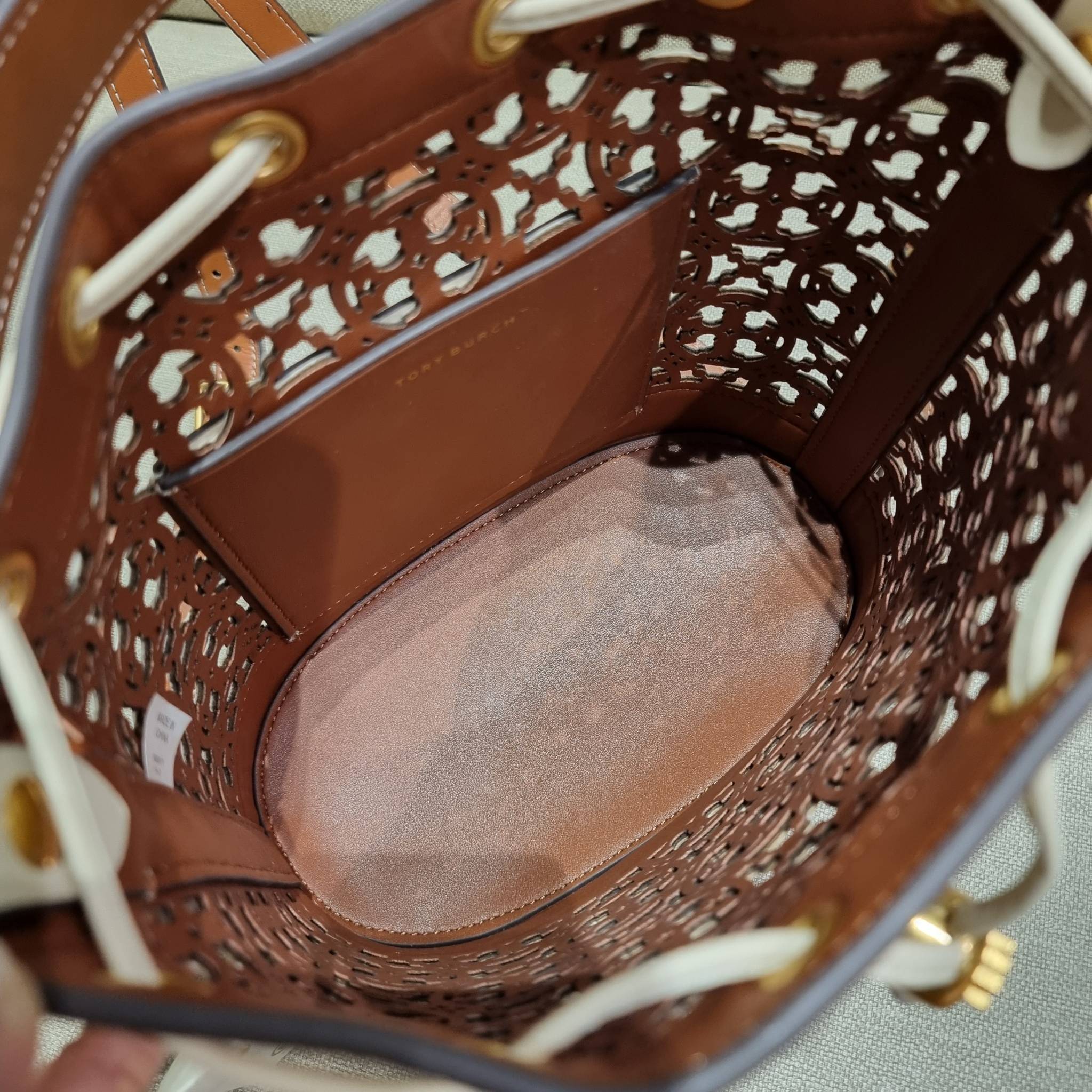 TORY BURCH T MONOGRAM LASER-CUT BUCKET BAG ใจบางที่สุดกับคอลเลคชั่นนี้ กับกระเป๋าสะพายทรงบัคเก็ต รุ่นชูโรงสุดฮิต ที่เพิ่มดีเทลความแพงด้วยการฉลุลวดลายโมโนแกรมรอบใบ ถักทอเป็นเส้นลายสานที่สวยงามมาก งานฝีมือจริงๆ วัสดุหนัง cowhide รูดเปิด-ปิดด้วยเส้นหนัง มาพร