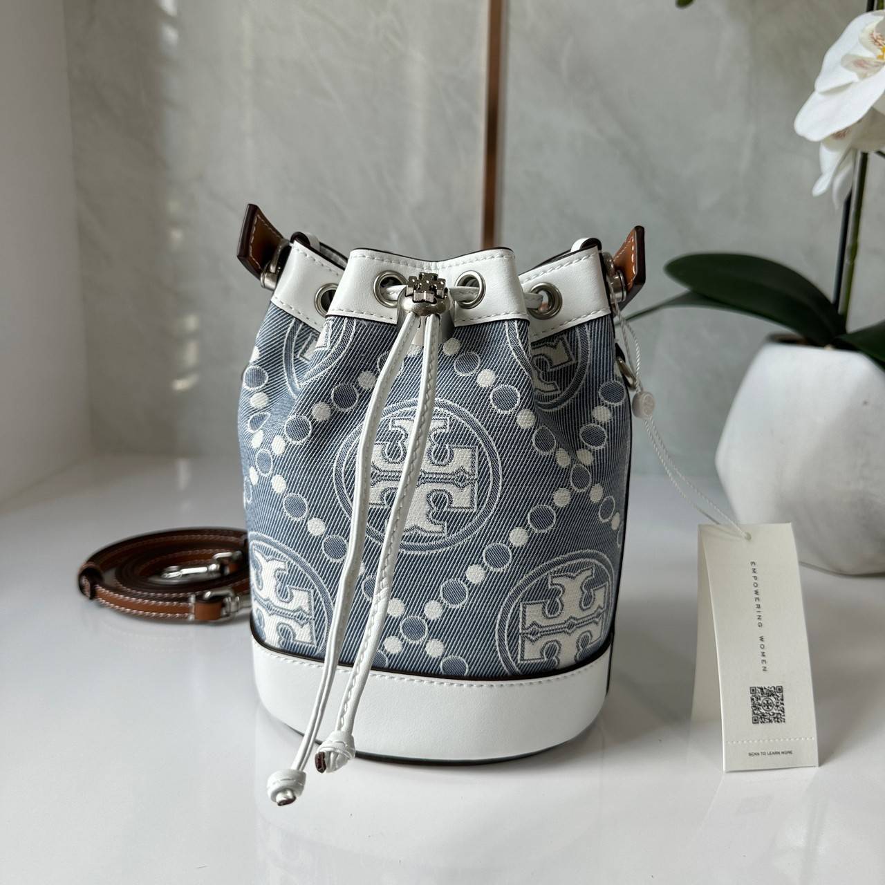 TORY BURCH Mini T Monogram Denim Bucket Bag คอลเลคชั่นใหม่ รูปแบบคลาสสิค พกพาความหรูหราไปได้ทุกที่ด้วยกระเป๋าทรง Bucket ขนาดกลางและปิดด้วยเชือกรูดพร้อมโลโก้แวววาว วัสดุผ้าเดนิมแจ็คการ์ด ตัดขอบหนังแท้ สวยหรู ทันสมัยสุดๆคะ