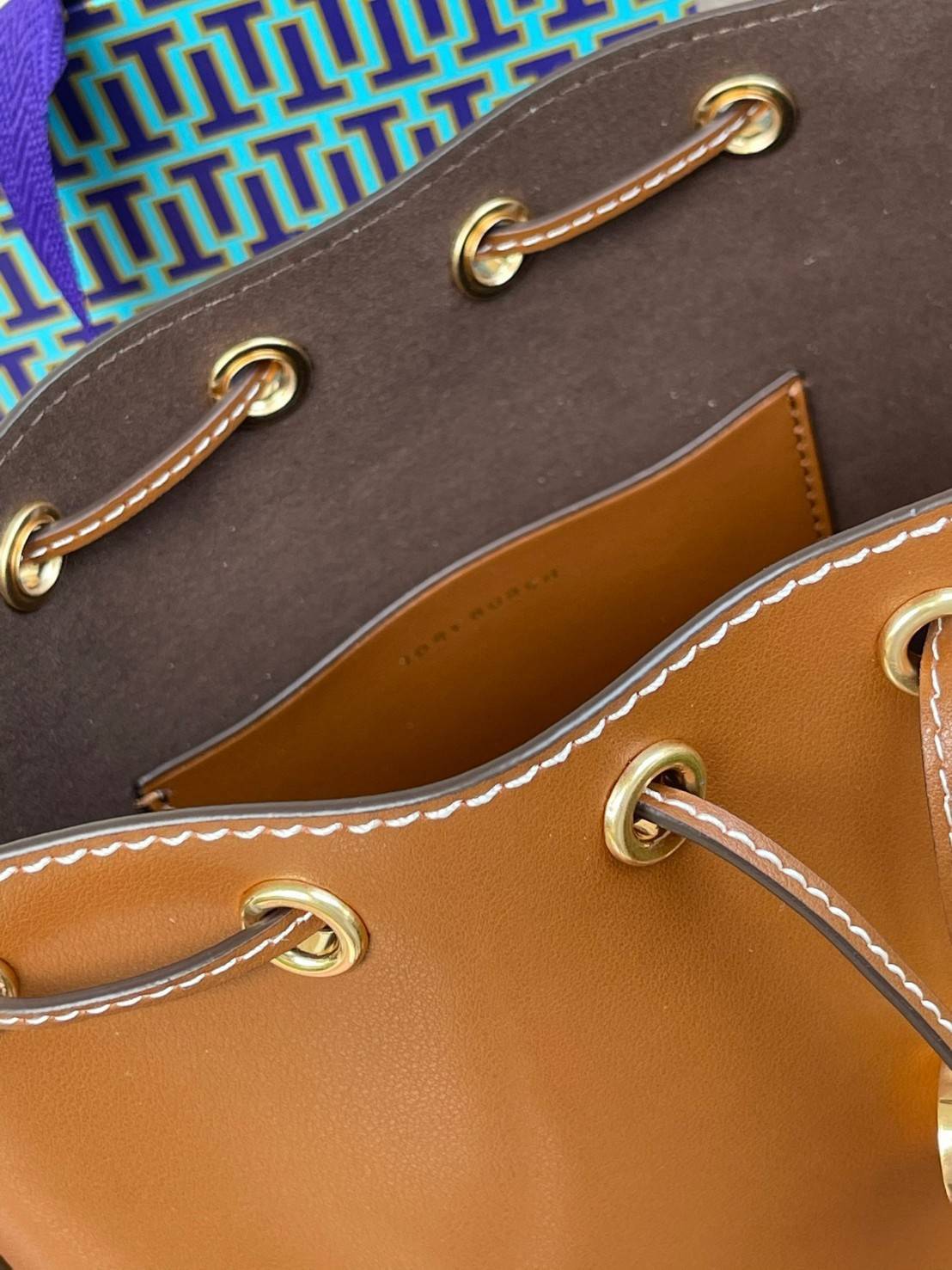 Tory burch T monogram leather bucket bag ดีไซน์สวยงามตามแบบฉบับของแบรนด์แล้ว ยังคงคำนึงถึงการใช้ได้จริงในชีวิตประจำวันอีกด้วย ไม่ว่าจะเป็นกระเป๋าสะพายมาในแบบ Tote Bag ที่ทำจากวัสดุหนังแท้