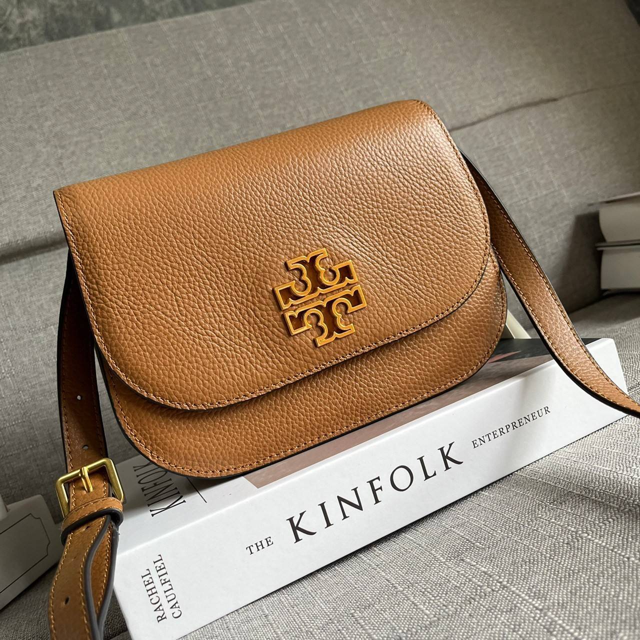 TORY BURCH BRLTTEN SMALL SADDLE BAG / Tory Burch Britten Flap Shoulder Bag กระเป๋าสะพายข้าง วัสดุหนังแกะแท้ ด้านหน้าประดับโลโก้แบรนด์ เปิด-ปิดกระเป๋าแบบกระดุมแป็กแม่เหล็กแน่นหนา ภายในมีช่องหลัก ใส่กระเป๋าเงินใบกลาง มือถือได้ทุกรุ่น มีช่องแยกใส่ของจุกจิกอี