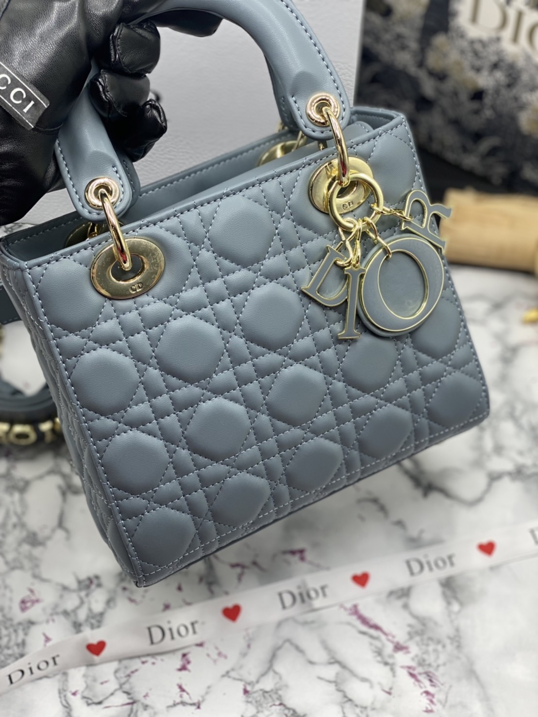หนังแท้ DIOR LADY BAG 20cm ความสง่างามอีกหนึ่งรุ่นของ Dior รูปทรงสีเหลียม ขนาดกระทัดรัด ตั้งอยู่ทรง ฐานกระเป๋าแข็งแรง มีหมุดรองฐาน ดีไซน์ที่มีเอกลักษณ์เฉพาะตัว ด้านหน้าตกแต่งด้วยตัวอักษร D.I.R ห้อยเป็นพวงกุญแจ จะถือด้วยมือหรือสะพายไหล่ก็ดูดีมากๆ ค่ะ
