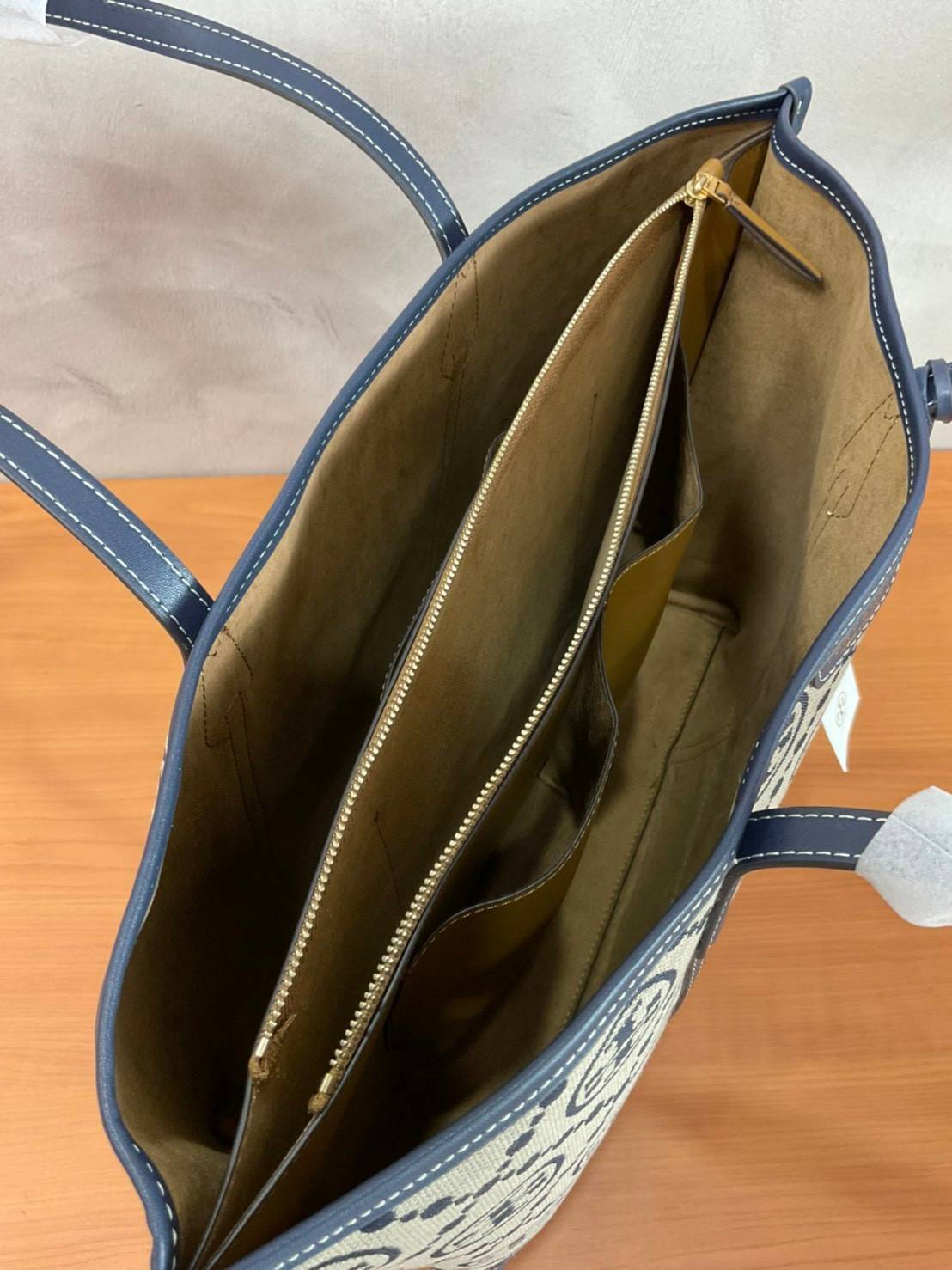 TORY BURCH T MONOGRAM TRIPLE - COMPARTMENT TOTE กระเป๋า/สะพายไหล่ทรง SHOPPING BAG วัสดุผ้าผ้าแคสวาสปักลายสัญลักษณ์แบรนด์ ตั้งอยู่ทรง สวยหรู ดูแพง จุของได้เยอะมาก ภายในแยกเป็น 2 ช่องหลัก 1 ช่องซิปตรงกลาง แบ่งเป็นสัดส่วนใช้งาน