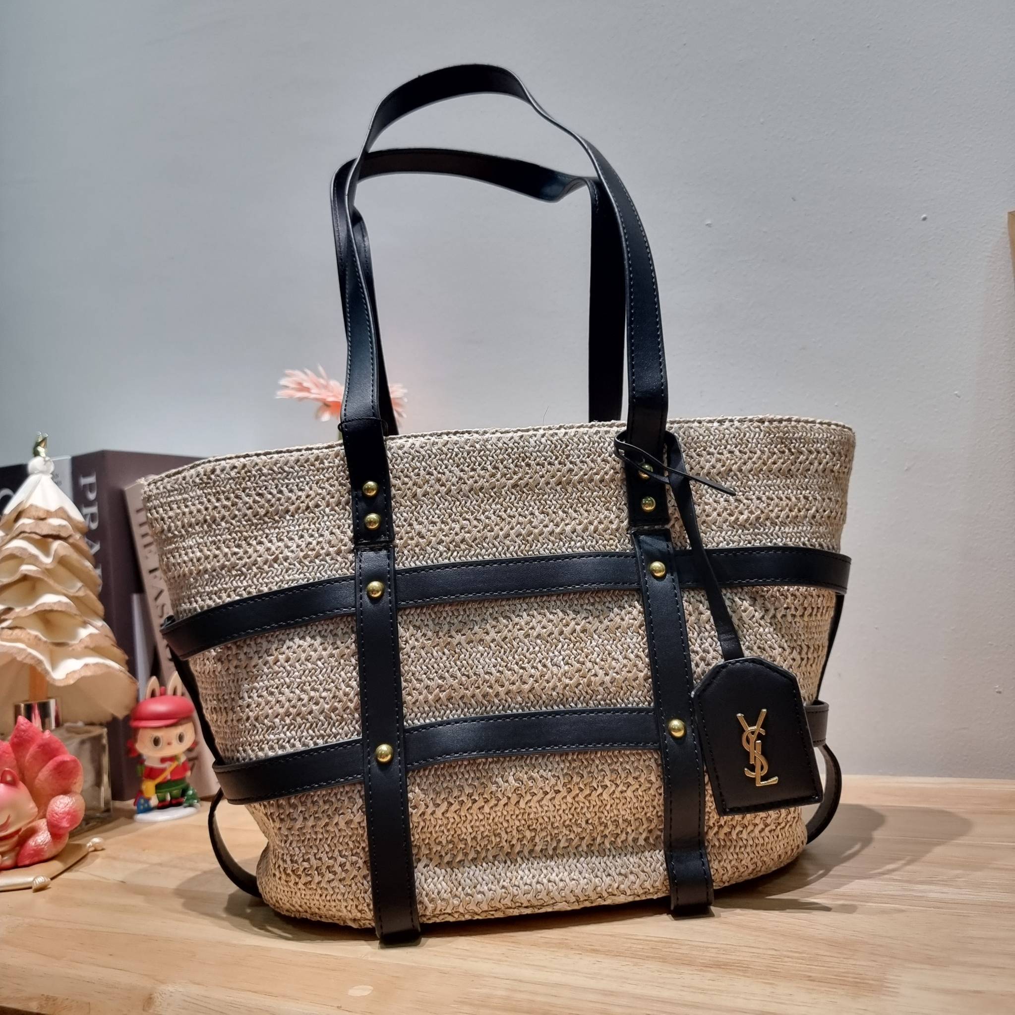 YSL PANIER STUDDED LEATHER TRIMMED WOVEN RAFFIA สวยไม่ซ้ำใคร ใหม่ที่สุด กับกระเป๋าสะพายสานทรงยูนีค ที่เติมดีเทลความหรูด้วยสายหนังคาดตกแต่ง ดูแพงไปอีก