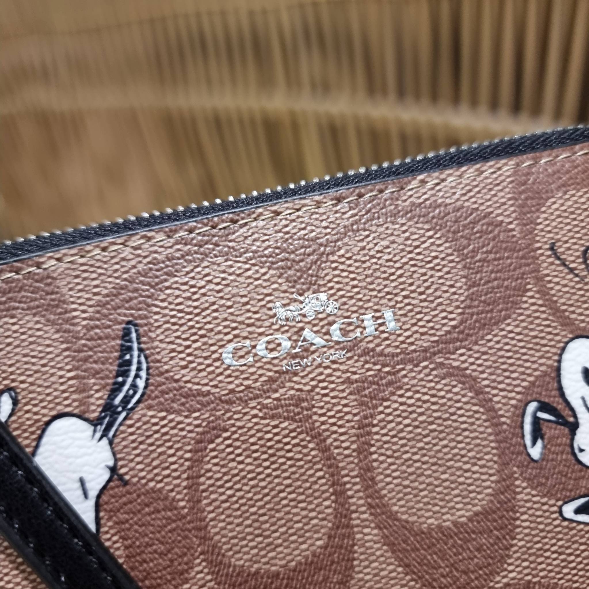 COACH C4589 COACH x PEANUTS CORNER ZIP WRISTLET IN SIGNATURE CANVAS WITH SNOOPY PRINT เหล่าผองเพื่อนและสนูปพีมาแล้วจ้า คอลเลคชั่นสุดน่ารักที่ฮอตไม่มีตก กระเป๋าคล้องมือ ขนาดเหมาะพกพากำลังเหมาะ วัสดุหนังแคนวาสเคลือบลาย ภายในเป็นช่องโล่ง ใส่ธนบัตร หรือใส่บัต