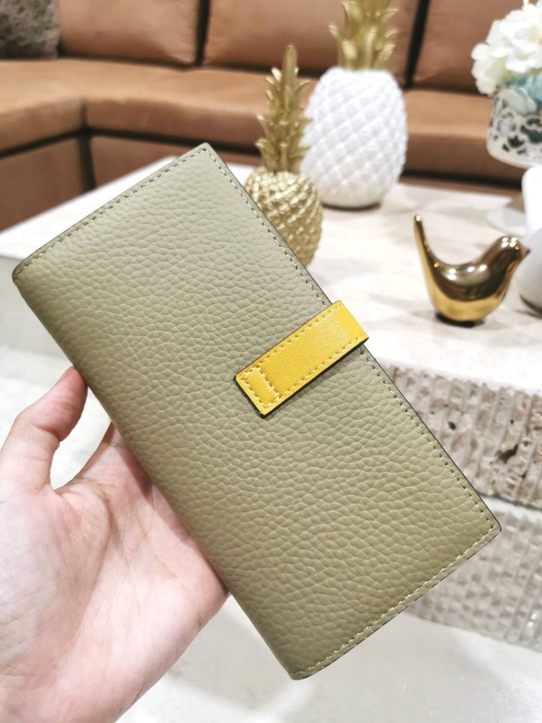 LOEWE LONG WALLET BAG วัสดุหนังแท้เทคเจอร์สวยอยู่ทรงปั้มโลโก้แบรนด์ด้านหน้าเปิดปิดด้วยกระดุม ภายในมีช่องใส่ธนบัตรหลายช่อง ช่องหลักสามารถใส่มือถือได้ มีช่องซิปใส่เหรียญ ช่องใส่ธนบัตรใส่แบงก์พันได้ สวยน่าใช้ พร้อมส่งที่ไทยสุดคุ้มห้ามพลาด!