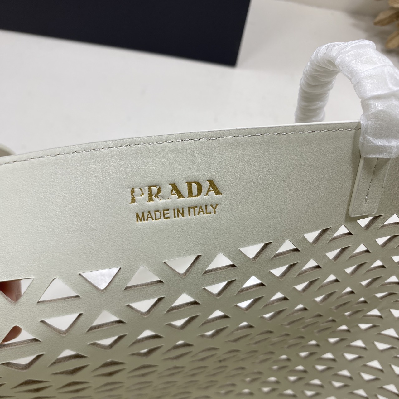 TOP ORI หนังแท้ | Prada Large perforated leather tote bag กระเป๋าทรงโท้ทใบใหญ่ ใจบางที่สุดกับคอลเลคชั่นนี้ ที่เพิ่มดีเทลความแพงด้วยการฉลุลวดลายรอบใบ ถักทอเป็นเส้นลายสานที่สวยงามมาก งานฝีมือจริงๆ