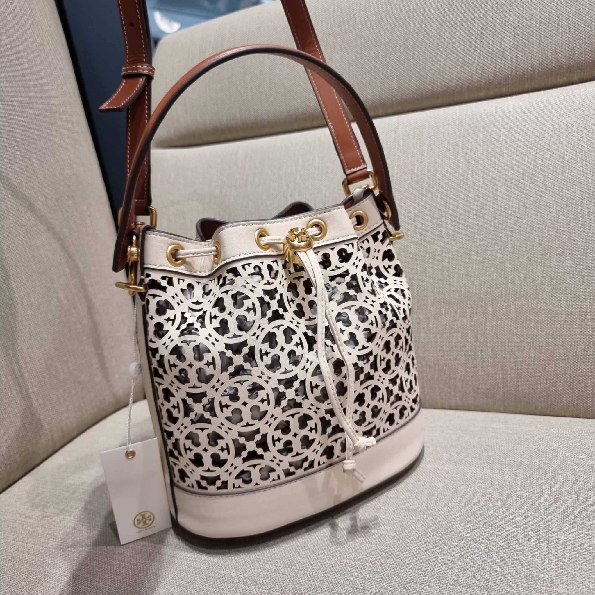 TORY BURCH T MONOGRAM LASER-CUT BUCKET BAG ใจบางที่สุดกับคอลเลคชั่นนี้ กับกระเป๋าสะพายทรงบัคเก็ต รุ่นชูโรงสุดฮิต ที่เพิ่มดีเทลความแพงด้วยการฉลุลวดลายโมโนแกรมรอบใบ ถักทอเป็นเส้นลายสานที่สวยงามมาก งานฝีมือจริงๆ วัสดุหนัง cowhide รูดเปิด-ปิดด้วยเส้นหนัง มาพร