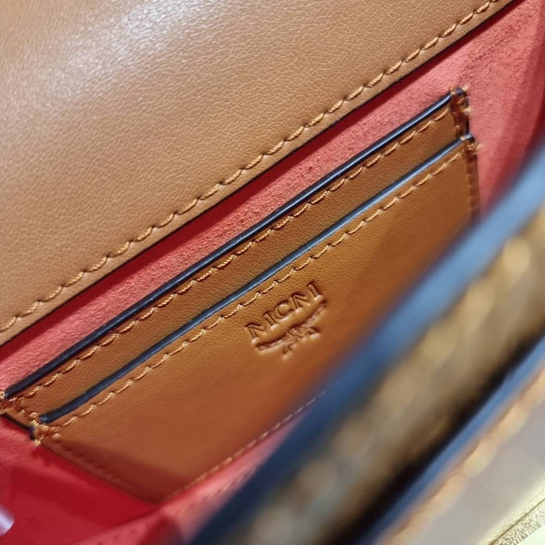 M.C.M MINI PATRICIA CROSSBODY IN VISETOS กระเป๋าสะพายไซส์มินิ แรงดีไม่มีตกน้า คอลเลคชั่นนี้ดีไซน์แปลกใหม่ ทรงโค้งมน สวยหรู ด้านข้างตกแต่งหมุดทองรอบใบ วัสดุตัวกระเป๋าเป็นหนังแคนวาสคุณภาพดี ภายในเป็นหนังกลับสีส้มโดดเด่นเป็นเอกลักษณ์ มีช่องใส่บัตรแยกให้ เปิด