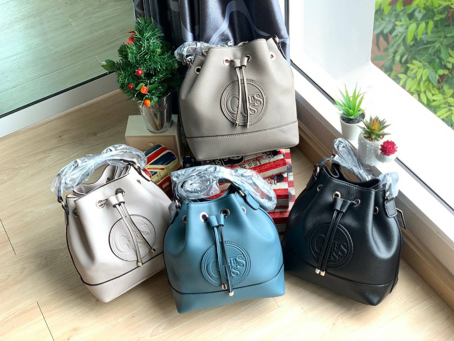 Guess Drawstring Bucket Bag กระเป๋าสะพายขนาดกลาง วัสดุลายหนังsaffiano ฐานกว้างตั้งอยู่ทรง มีซิกเนเจอร์ที่ด้านหน้าเป็นโลโก้ตัวนูน เปิดปิดแบบหูรูดและกระดุมแม่เหล็ก มีช่องใช้งานหลายข่อง สายสะพายปรับได้แบบเข็มขัด สวยแบบมีดีเทลเก๋ๆ สะพายเที่ยวระหว่างวันได้สบาย