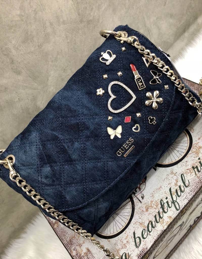 GUESS WOMEN BAG JEAN กระเป๋าสะพายไหล่หรือ crossbody สุดชิค วัสดุผ้ายีนส์ ด้านหน้าติด logo brand เพิ่มดีเทลดีไซน์ตกแต่งที่ด้านหน้ากระเป๋า เปิดปิดกระเป๋าแบบแม่เหล็ก ใช้งานง่าย ภายในมี 2 ช่อง แต่ละช่องกว้างใส่ของได้จุ และยังมีช่องซิปเล็กใส่ของจุกจิกได้อีกค่ะ