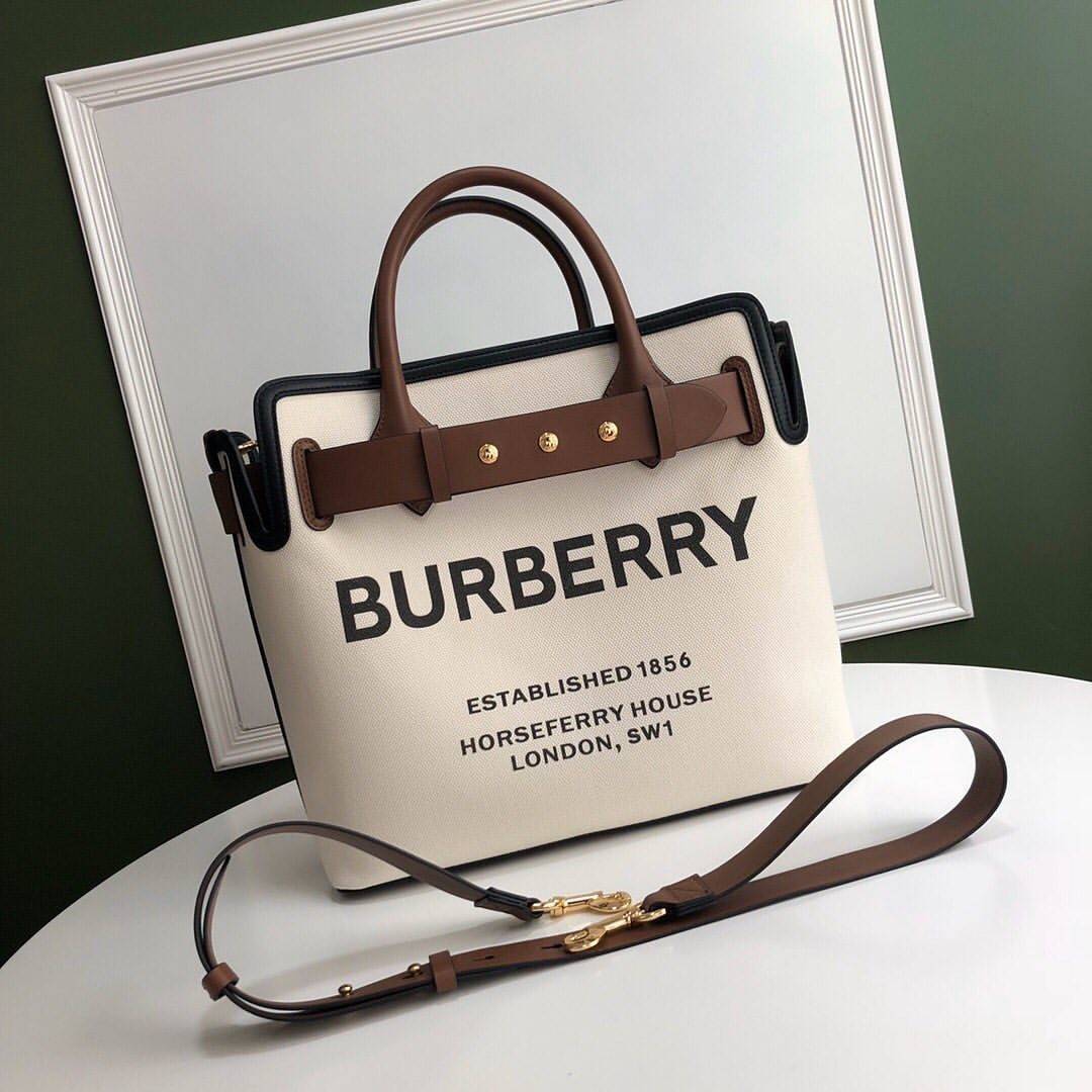 BURBERRY FRAGRANCES TOTE BAG อีกหนึ่งไอเท็มหายาก วัสดุ Canvas & Leather Calfskin ดีไซน์สวยมีเอกลักษณ์คาดด้วยสายหนังประดับกระดุมทองด้านหน้า หูจับหนังแท้จับถนัดมือ สายสะพายยาวหนังแท้ถอดได้ปรับระดับได้อะไหล่แบรนด์ ภายในโล่งกว้างมีช่องใส่ของใส่เอกสารA4 กระเป๋