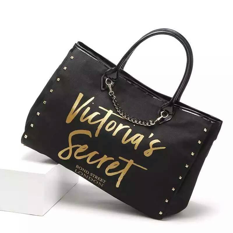 Victoria's Secret Canvas tote bag New Arrival กระเป๋าถือหรือสะพายทรง tote size L ใบใหญ่จุใจ วัสดุ Canvas หนา ด้านหน้าประดับโซ่ทอง สลับหนัง พร้อมสกรีนแบรนด์ Victoria's Secret และ ประดับหมุดด้านข้างเท่ๆห์เพิ่มดีเทล ปรับใช้ได้สองทรงค้า ภายในกว้างมี