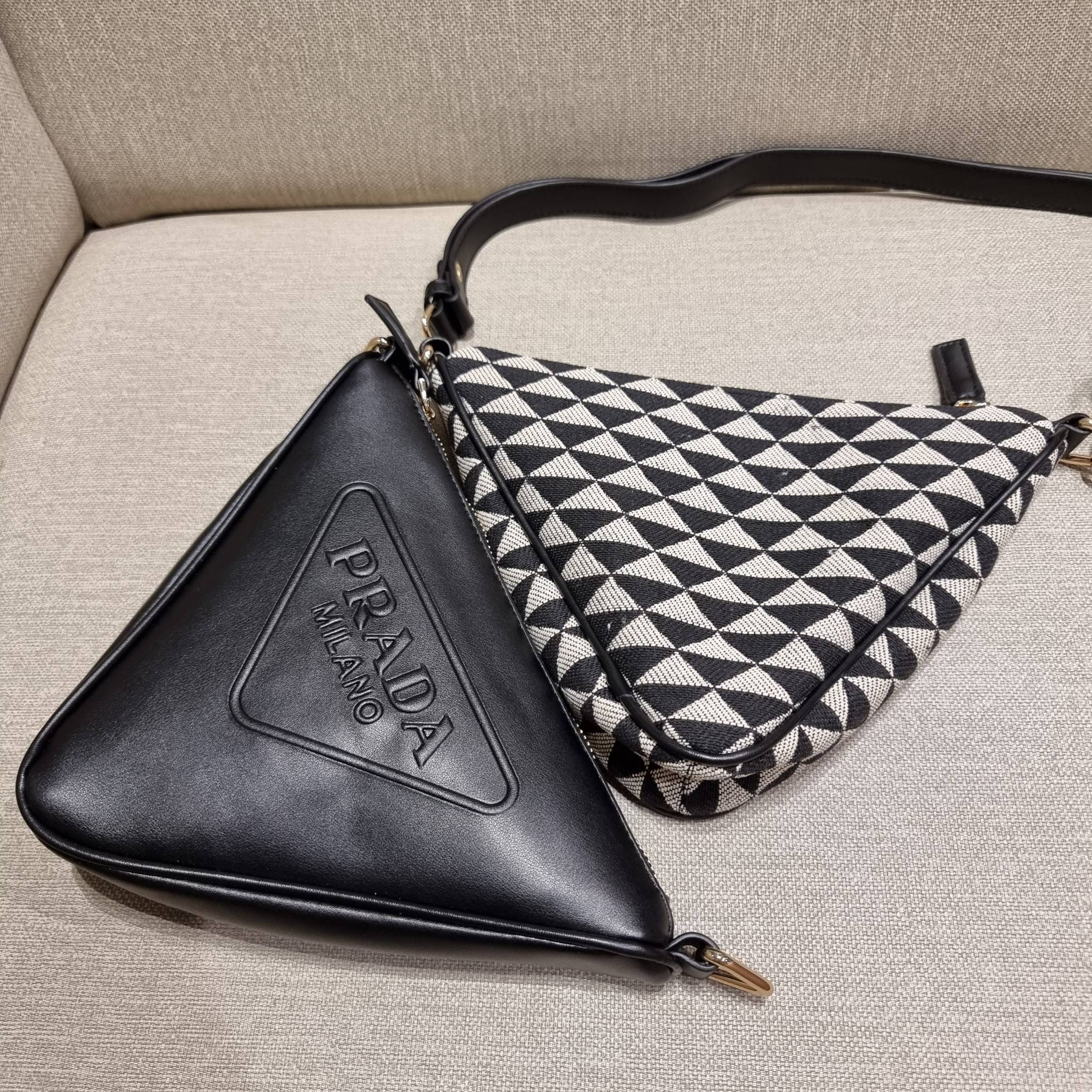 PRADA TRIANGLE BAG ล้ำกว่าใคร ใหม่กว่าใคร ไม่ต้องรอพรีฯ กระเป๋าสะพาย ดีไซน์ทรงสามเหลี่ยม ชิคๆคูลๆ ไม่มีใครเหมือน มีมาให้ถึง 2 ชิ้น วัสดุผ้า jacquard และหนังแท้ สวยคู่ สลับใช้ได้หลากหลายมากๆ เพราะยังมีสายสะพายมาให้อีกถึง 2 เส้น เกี่ยวคู่กันสะพายเท่ๆ หรือแย