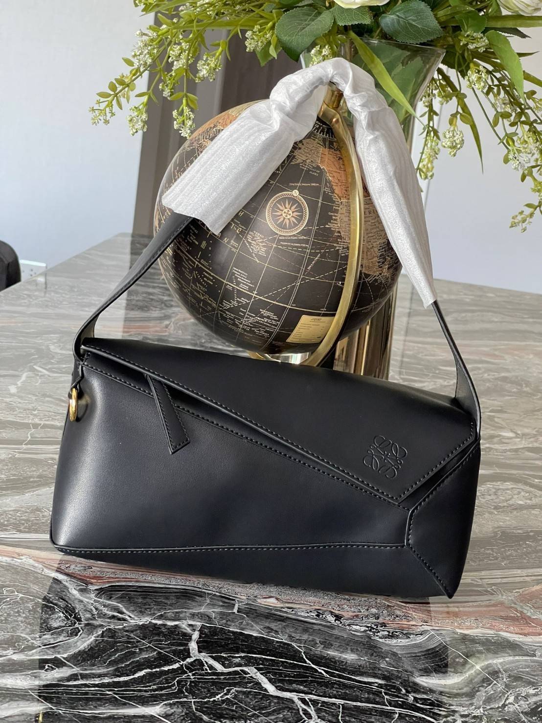 Loewe Puzzle Hobo bag กระเป๋ารุ่น Puzzle มีความพิเศษในหลายด้าน ไม่ว่าจะเป็นรูปทรงที่แปลกใหม่ มินิมอลด้วยโลโก้อนาแกรมแบบประทับ ดูหรู เป็นกระเป๋า Unisex ที่ไม่ว่าคุณจะเป็นผู้หญิงหรือผู้ชายก็ใช้งานได้ ลายกระเป๋าได้มาจากการนำหนังมาเย็บต่อกันทั้งหมด ถึงแม้ว่าข