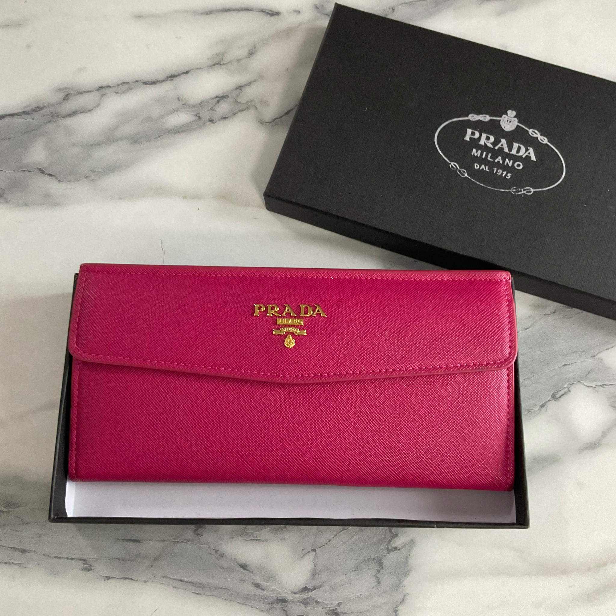 PRADA LONG WALLET Best Seller กระเป๋าสตางค์รับทรัพย์ ทรงหรู ลายหนัง SAFFIANO มีช่องใส่บัตร ถึง 12 ช่อง และช่องซิปใส่ของจุกจิกได้ น้ำหนักเบา จับถนัดมือ ขนาดกำลังดี