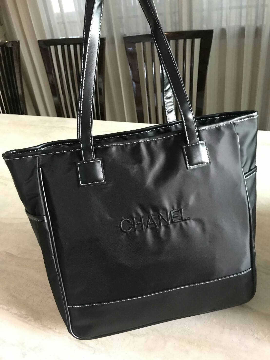 NEW! Chanel Shopping Bag with Ribbin พรีเมี่ยมกิ้ฟของแท้จาก Chanel Cosmetic Counter วัสดุ Polyester & Nylon เนื้อหนาตัดหนังเรียบสีดำเพิ่มความแข็งแรงอยู่ทรง เปิดปิดด้วยซิปสะดวกใช้ น้ำหนักเบา จุสุดๆค่ะ ภายในมีช่องซิปและช่องใส่ของหลายช่อง ใส่เอกสาร A4 หนังสื