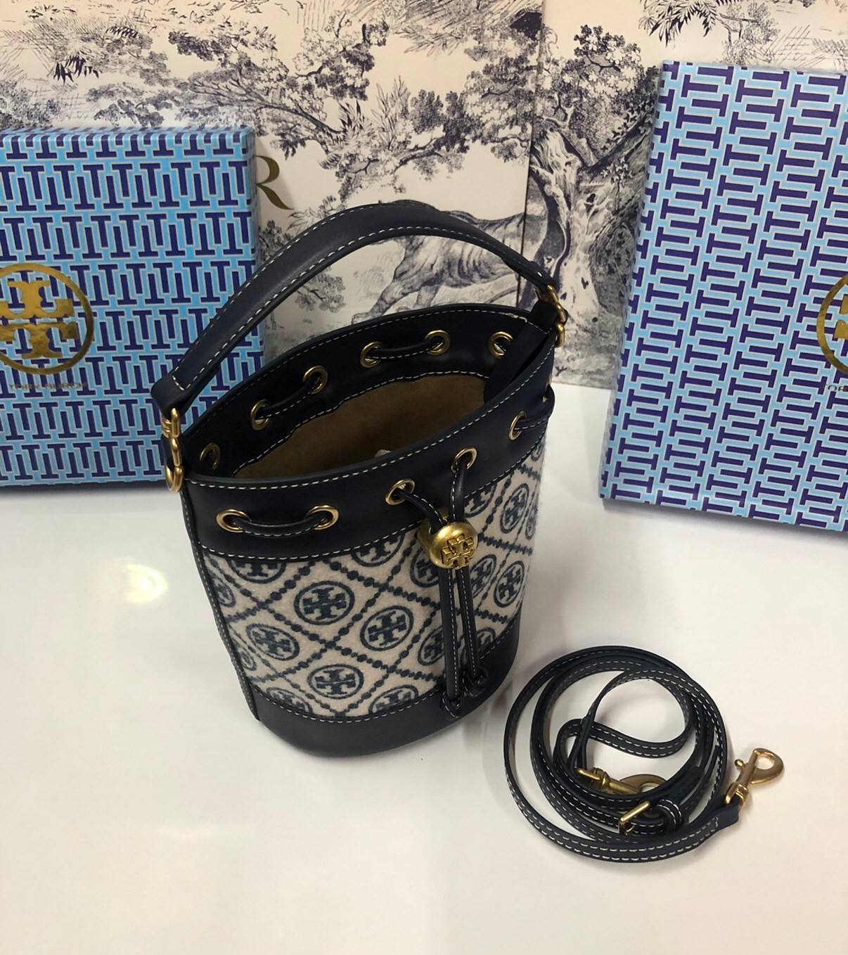 Mini : Tory Burch T Monogram Chenille Bucket Bag เปิดตัวอีกหนึ่งรุ่นกับกระเป๋าลาย T MONOGRAM รุ่นใหม่ล่าสุดจาก TORY BURCH พลาดไม่ได้กับโลโก้สุดคลาสสิก ลวดลาย T Monogram คือวัสดุ chenille หรือที่เรียกว่า ด้านไหมกำมะหยี่ มารังสรรค์ลงบนกระเป๋าBucketใบนี้ เป็