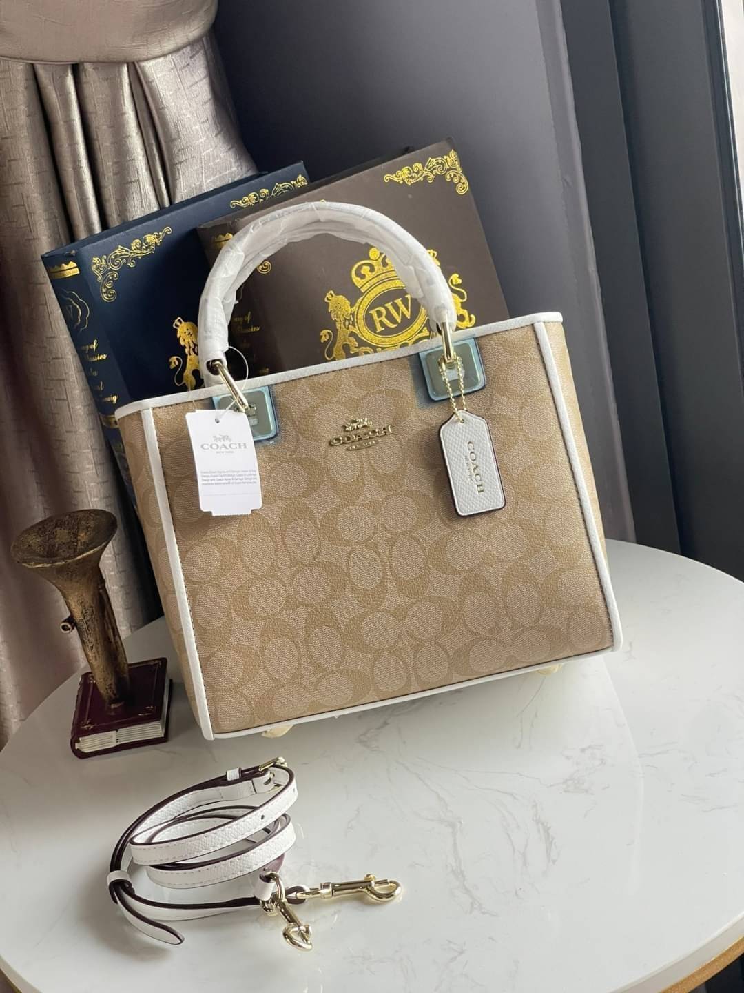 Coach Perry Tote Classic Bag F57568 รุ่นใหม่ล่าสุด กระเป๋ารูปทรงสี่เหลี่ยมสุดคลาสสิก เป็นกระเป๋าอเนกประสงค์ที่สามารถใช้ได้แทบทุกโอกาส ไม่ว่าจะไปเรียน, ไปทำงาน, ไปเที่ยว หรือแม้แต่ไปชอปปิง ด้วยขนาดที่กำลังดี ไม่ใหญ่เทอะทะ แต่ก็ไม่เล็กจนเกินไป มาพร้อมหูหิ้ว