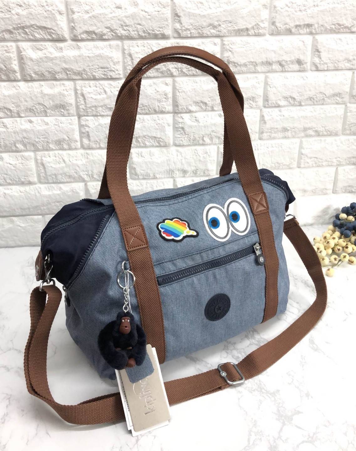 Kipling ART Emoji Limited edition (HK. oem factory) กระเป๋าถือหรือสะพายข้าง วัสดุผ้ากึ่งยีนส์ คุณภาพดี เนื้อผ้าสวยมากๆค่ะ ด้านหน้าตกแต่ง emoji เพิ่มความน่ารัก มีช่องซิปหนึ่งช่อง เปิดปิดกระเป๋าด้วยซิป ภายในบุซับในลาย emoji สวยมากๆค่ะ. มีช่องเล็ก, ช่องซิป แ