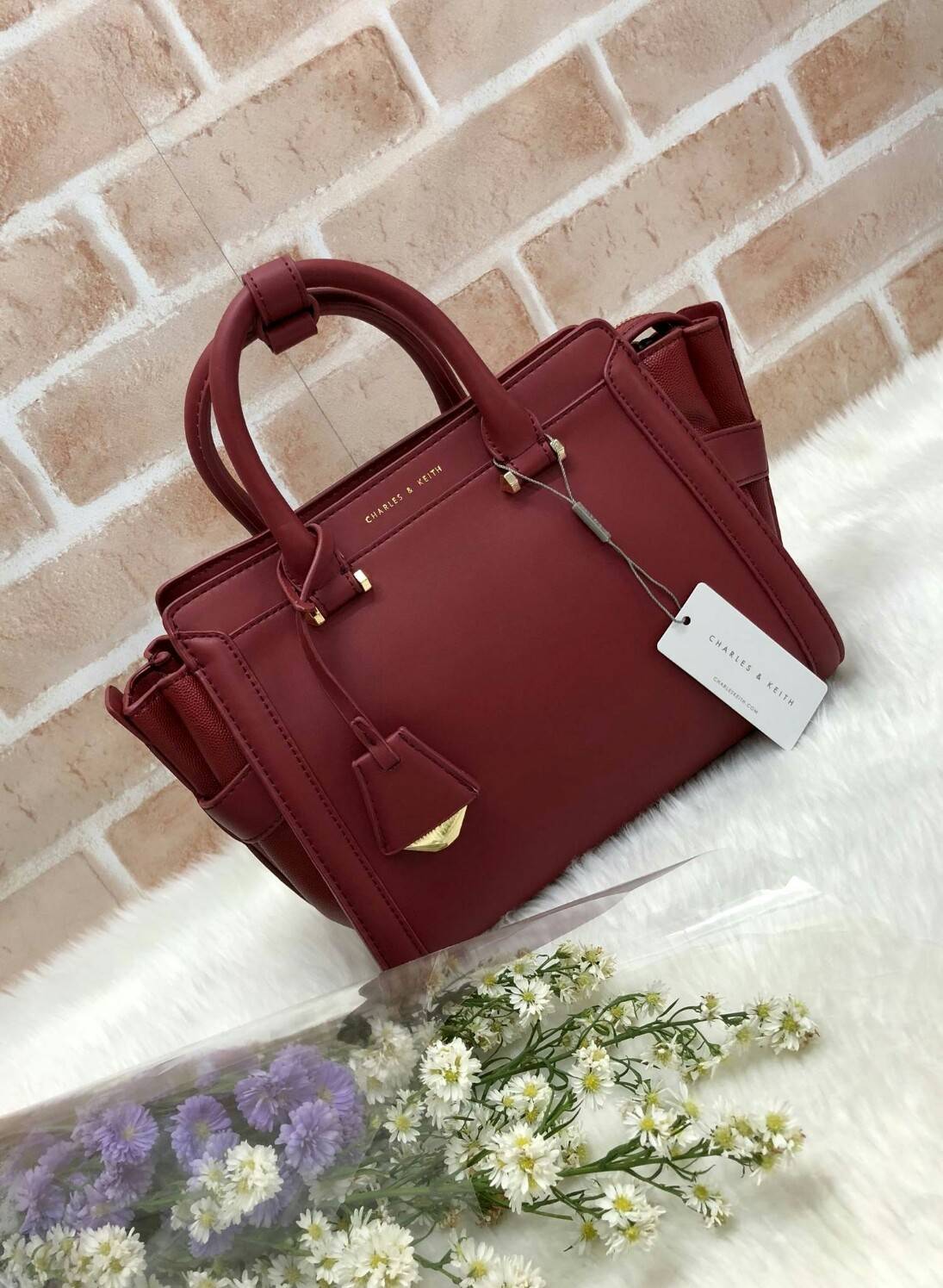 CHARLES & KEITH TRAPEZE BAG (หนังเรียบ) กระเป๋าถือหรือสะพายรุ่นยอดนิยมดีไซน์สวยหรู - วัสดุหนังลายคาร์เวียร์ สวยอยู่ทรง - ด้านข้างเเต่งช่องตัดดูมีดีเทล - ด้านหน้าสกรีนโลโก้ ด้านหลังมีช่องซิป - เปิดปิดด้วยซิปหัวซิปปั๊มโลโก้ หูจับเเข็งแรง พับลงได้