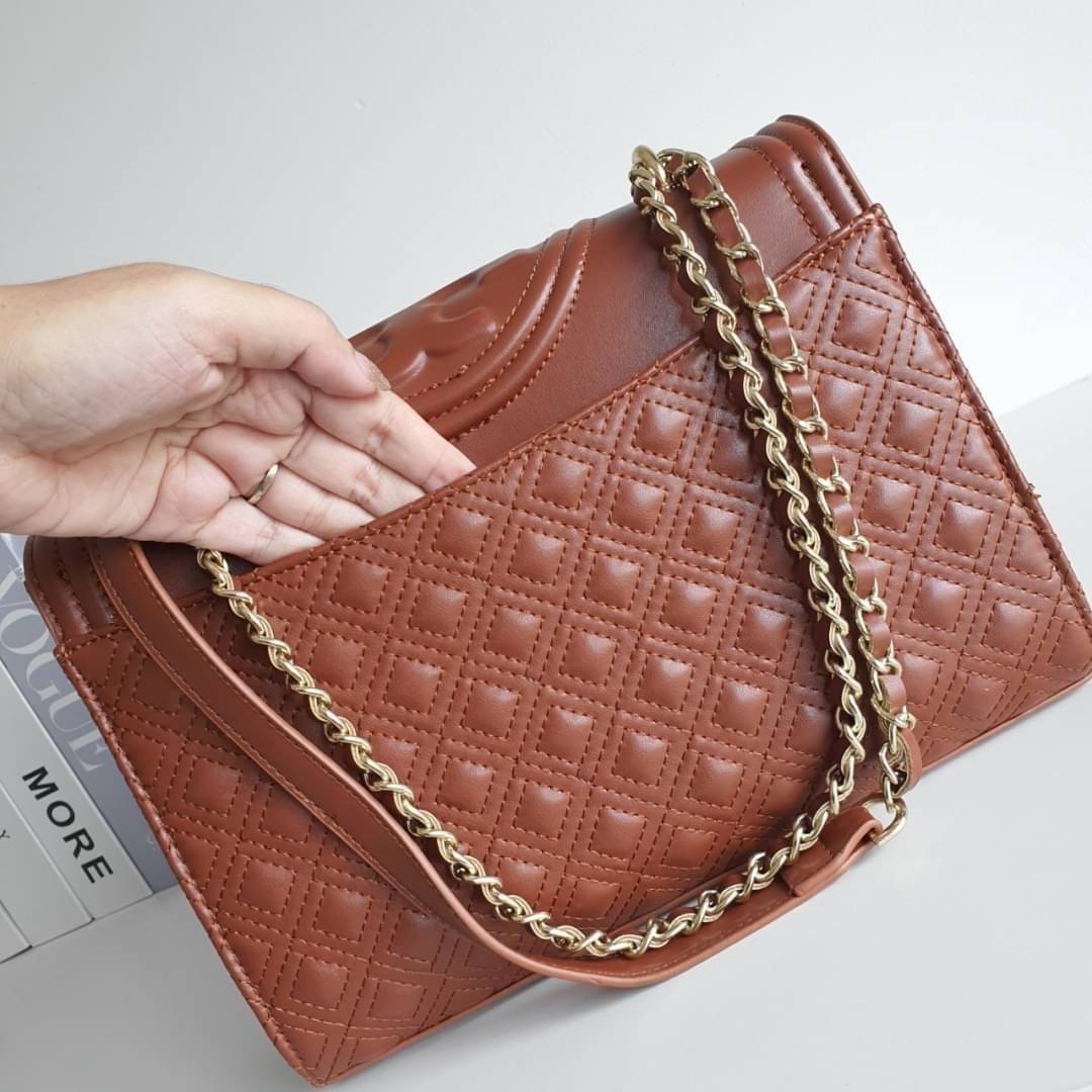 TORY BURCH Fleming Small Convertible Shoulder Bag รุ่นขายดีที่สุดกับ ไอเท็มที่ต้องมีแบรนด์ TORY BURCH มีมาให้ช้อปอีกแล้วค่ะสาวๆ กับทรง CLUCTH & CROSSBODY กระเป๋าสะพายข้างหรือสะพายเป็นครอสบอดี้ ประดับพู่ด้านข้าง