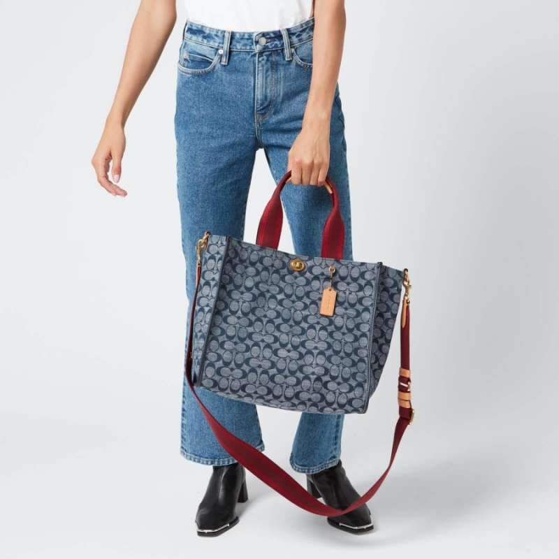 COACH Tote 34 In Signature Chambray หากคุณกำลังมองหากระเป๋าที่มีดีไซน์แปลกตา ไม่ค่อยเหมือนที่พบเห็นทั่วไป ต้องเป็นรุ่นนี้เลยค่ะ นอกจากจะผลิตจากผ้าแชมเบรย์ซึ่งมีน้ำหนักเบาแล้ว ยังให้สีสันคล้ายกับสียีนส์ สายสะพายและหูหิ้วสไตล์สปอร์ต ที่สำคัญยังมีหมุดปิดกระเ