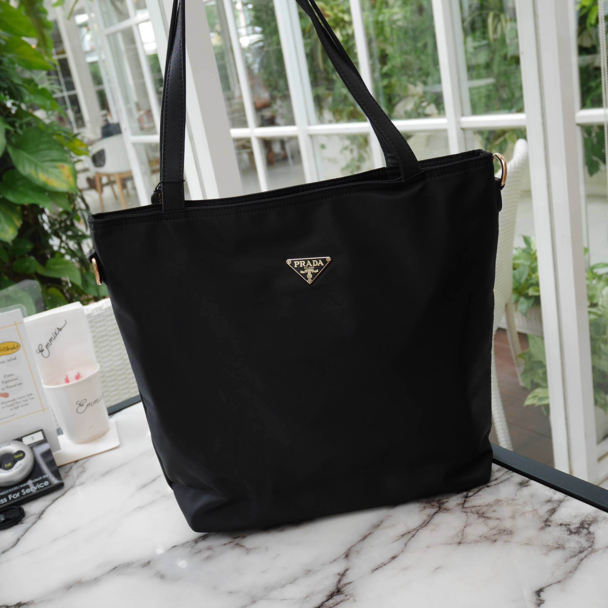 งานขายดีคะ ♡♡ กระเป๋าสะพาย ทรง TOTE จากแบรนด์ PRADA มาค่า ตัวกระเป๋าเป็น nylon ทั้งใบ สะพายเป็น shoulder bag หรือถือได้ค่ะ ด้านหน้าเป็นลายหมี ปักกลิ้ตเตอร์ + logo brand ใช้แล้วสวยมากๆ อะไหล่ทองหรูมาก จุของคุ้ม ใส่หนังสือ หรือ MacBook ได้ค้า 
