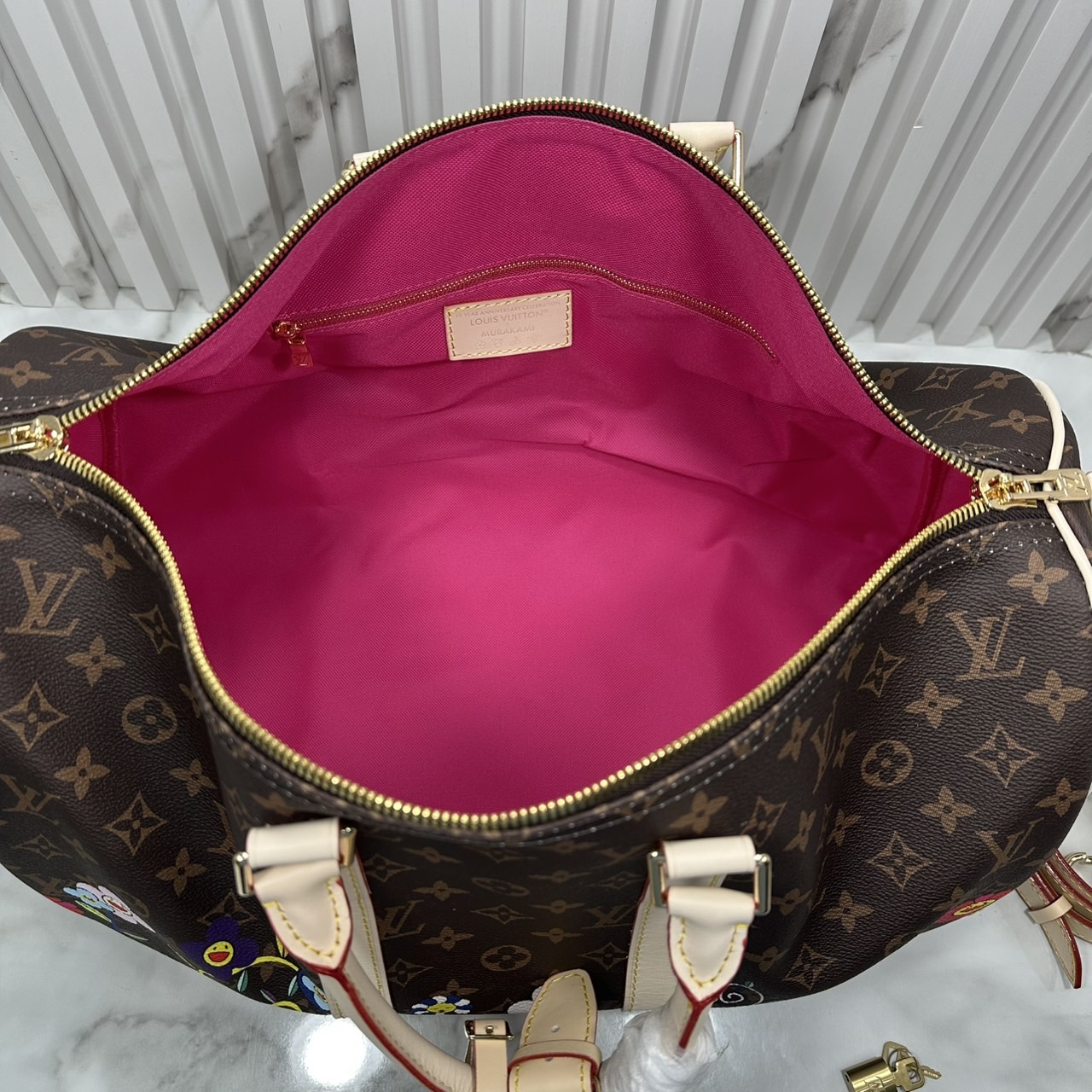 LV x TM Keepall Bandoulière 45 Bag Monogram Flower กระเป๋าเดินทางคอลเลกชันสุดพิเศษ สวยคลาสสิกมีชีวิตชีวา สีสันสดใสสไตล์ superflat สุดไอคอนิกของ Takashi Murakami ด้วยโมโนแกรมดอกไม้หลากสี ปรับดีไซน์ให้ดูสนุกสนาน