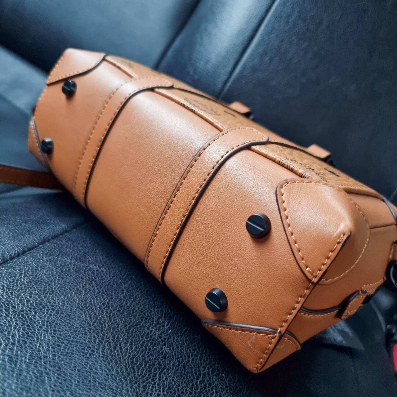 M.C.M SMALL E/W SOFT BERLIN CROSSBODY IN VISETOS ไอเท็มใหม่ในดีไซน์ทรงกระเป๋าเดินทางแบบคลาสสิค ย่อส่วนมาให้ใช้งานได้แบบสบายๆ พกพาสะดวก แมทช์ได้ทุกสไตล์ ใช้ได้แบบ unisex ใช้งานง่ายด้วยหูจับในตัว และซิปหลัก อะไหล่สีดำดูมีมิติตัดกับสีน้ำตาลคอนยัคได้เป็นอย่าง