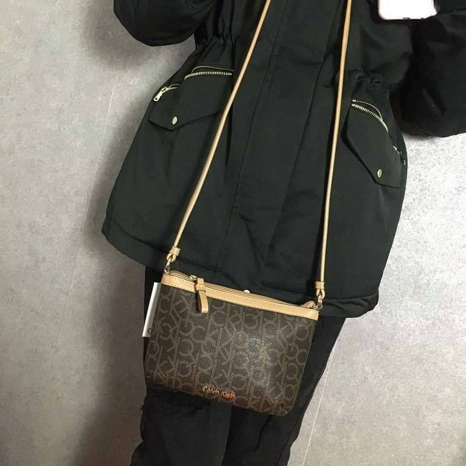 Calvin Klein Cross Body Bag กระเป๋าสะพายรุ่นใหม่ล่าสุดหนังสวย สกรีนลาย Signature แบรนด์รอบใบ ประดับโลโก้แบรนด์ สีทองด้านหน้า เปิดปิดด้วยซิป น้ำหนักเบา ภายใน โล่งกว้าง มีช่องใส่บัตร และช่องซิป ใส่ iphone+ ได้ มาพร้อมสายสะพายยาว ขนาดกำลังน่ารัก สะพายคล่องตั