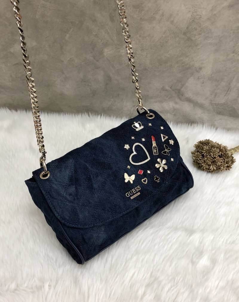 GUESS WOMEN BAG JEAN กระเป๋าสะพายไหล่หรือ crossbody สุดชิค วัสดุผ้ายีนส์ ด้านหน้าติด logo brand เพิ่มดีเทลดีไซน์ตกแต่งที่ด้านหน้ากระเป๋า เปิดปิดกระเป๋าแบบแม่เหล็ก ใช้งานง่าย ภายในมี 2 ช่อง แต่ละช่องกว้างใส่ของได้จุ และยังมีช่องซิปเล็กใส่ของจุกจิกได้อีกค่ะ