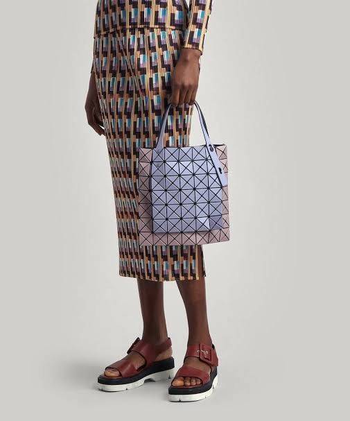 Baobao Issey Miyake Prism Kangaroo tote bag กระเป๋าถือทรงโท้ทที่ประดิษฐ์ขึ้นอย่างเชี่ยวชาญในญี่ปุ่น มาพร้อมแผงเรขาคณิตสำหรับการออกแบบที่ได้รับแรงบันดาลใจจากกระดาษพับ ซิลลูเอทอันเป็นเอกลักษณ์นี้ปิดท้ายด้วยสายรัดแบบอสมมาตร มีการพัฒนาโครงสร้างทรงสามเหลี่ยมเพ