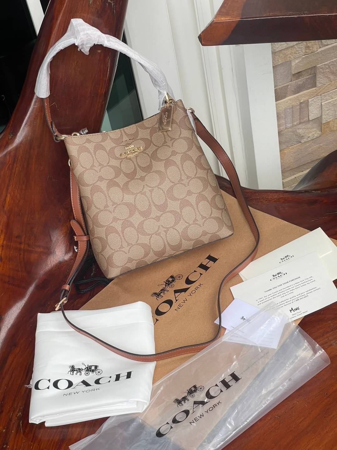 COACH SMALL TOWN BUCKET BAG IN SIGNATURE สำหรับสาวแฟชั่นที่ชอบรายละเอียดชิคๆ ดีไซน์สุดเก๋ แนะนำเลยสำหรับกระเป๋าทรงบักเก็ตใบนี้ เชื่อว่าสาว ๆ หลายคนชื่นชอบ เป็นไอเทมที่สามารถแมทช์ได้กับเสื้อหลากหลายสไตล์ บรรจุของได้เยอะโดยที่กระเป๋าไม่เสียทรง แบ่งช่องใช้งา