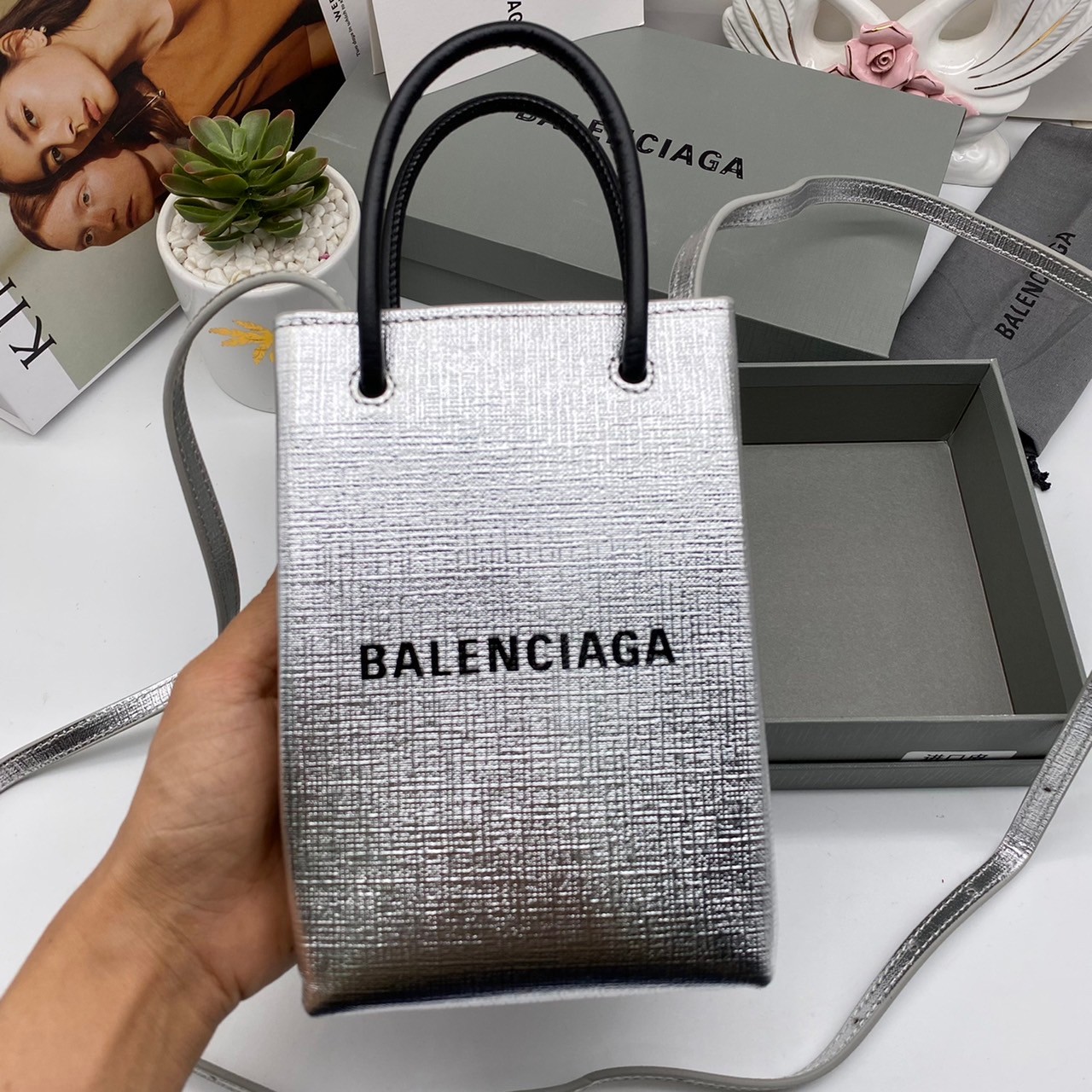 หนังแท้ BALENCIAGA Shopping Phone Pouch leather tote พกกระเป๋าช้อปปิ้งขนาดมินิ ไปทุกที่ในฤดูกาลนี้ ดีไซน์ที่ใช้ได้ทุกวันตั้งแต่หนังแบบมีเท็กซ์เจอร์ ภาพสินค้าถ่ายจากงานขายจริง ใช้งานต่างประเทศได้