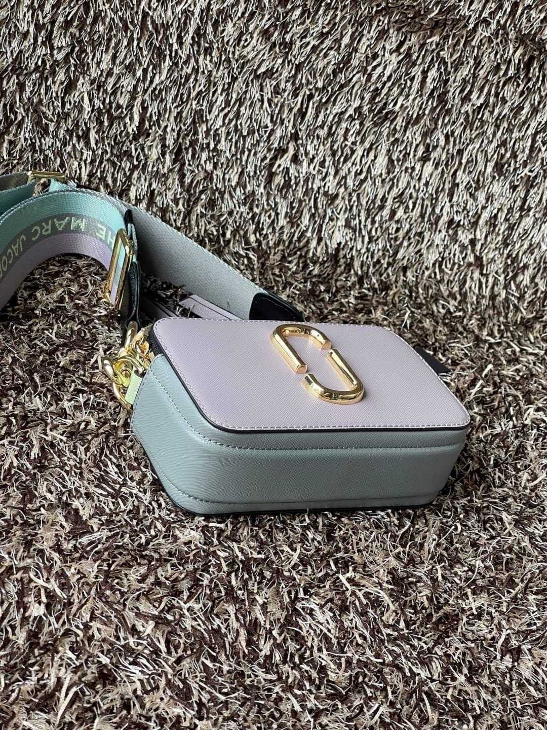 Marc Jacobs Snapshot Bag กระเป๋าแบรนด์ดังจากสัญชาติอเมริกัน นับได้ว่ารุ่นนี้เป็นรุ่นทรงฮิตเลยทีเดียว โดยด้านหน้ากระเป๋าจะเป็นโลโก้แบบโลหะที่เป็นสัญลักษณ์ของแบรนด์นี้ มาพร้อมสายสะพายที่จะสะพายยังไงก็ดูโดดเด่น เพราะขนาดใหญ่ที่สกรีนตัวอักษรโลโก้ ในรูปแบบต่าง